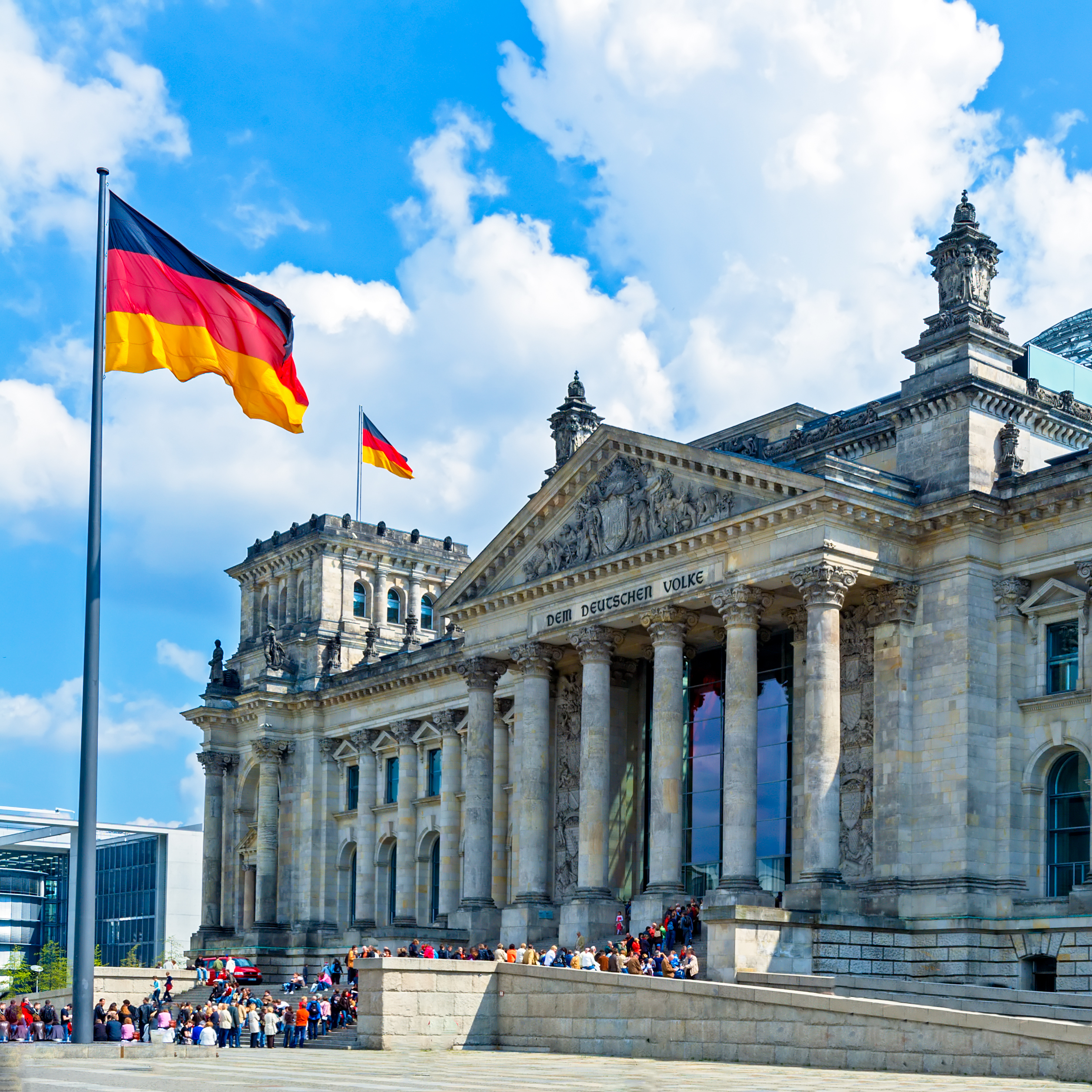 Den majestætiske Rigsdagsbygning i Berlin med glaskuppel og tysk flag, et populært rejsemål i Tyskland