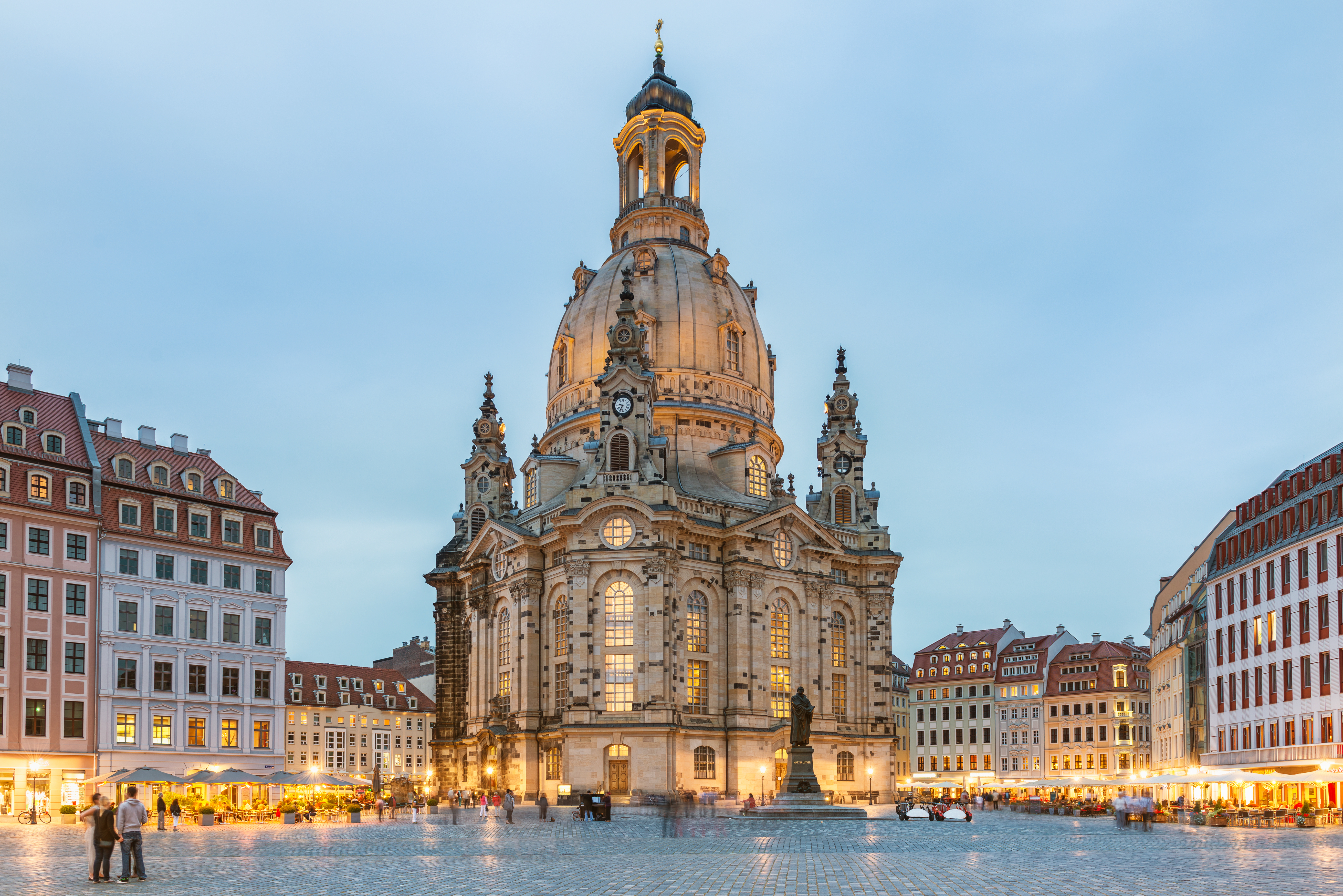 Den ikoniske Frauenkirche i Dresden badet i varmt aftenlys, omgivet af historiske bygninger på det centrale torv