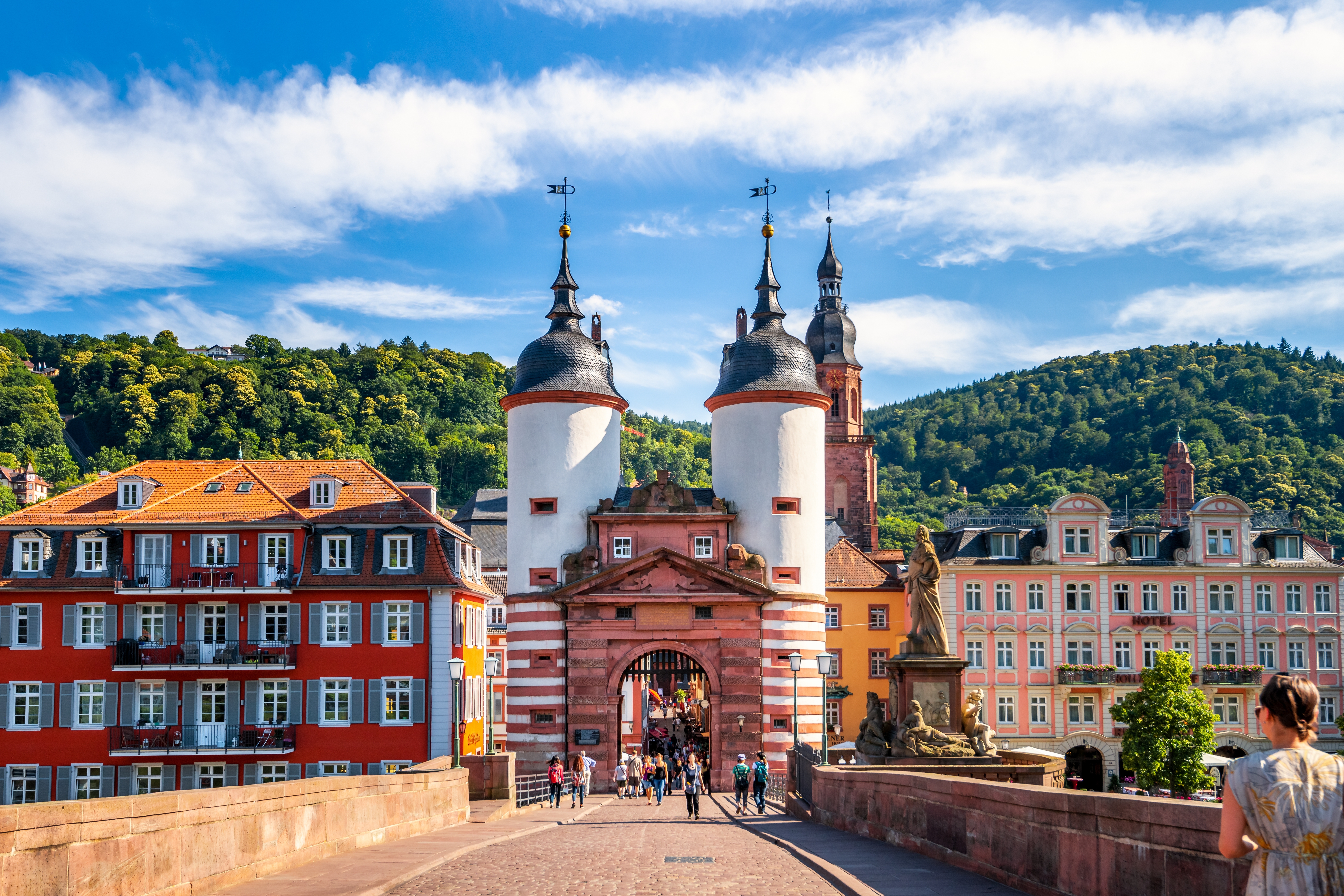 Fascinerende vue over Heidelbergs berømte Gamle Bro med dens karakteristiske tårnport, de velbevarede historiske bygninger og de skovklædte bakker der omkranser den romantiske by