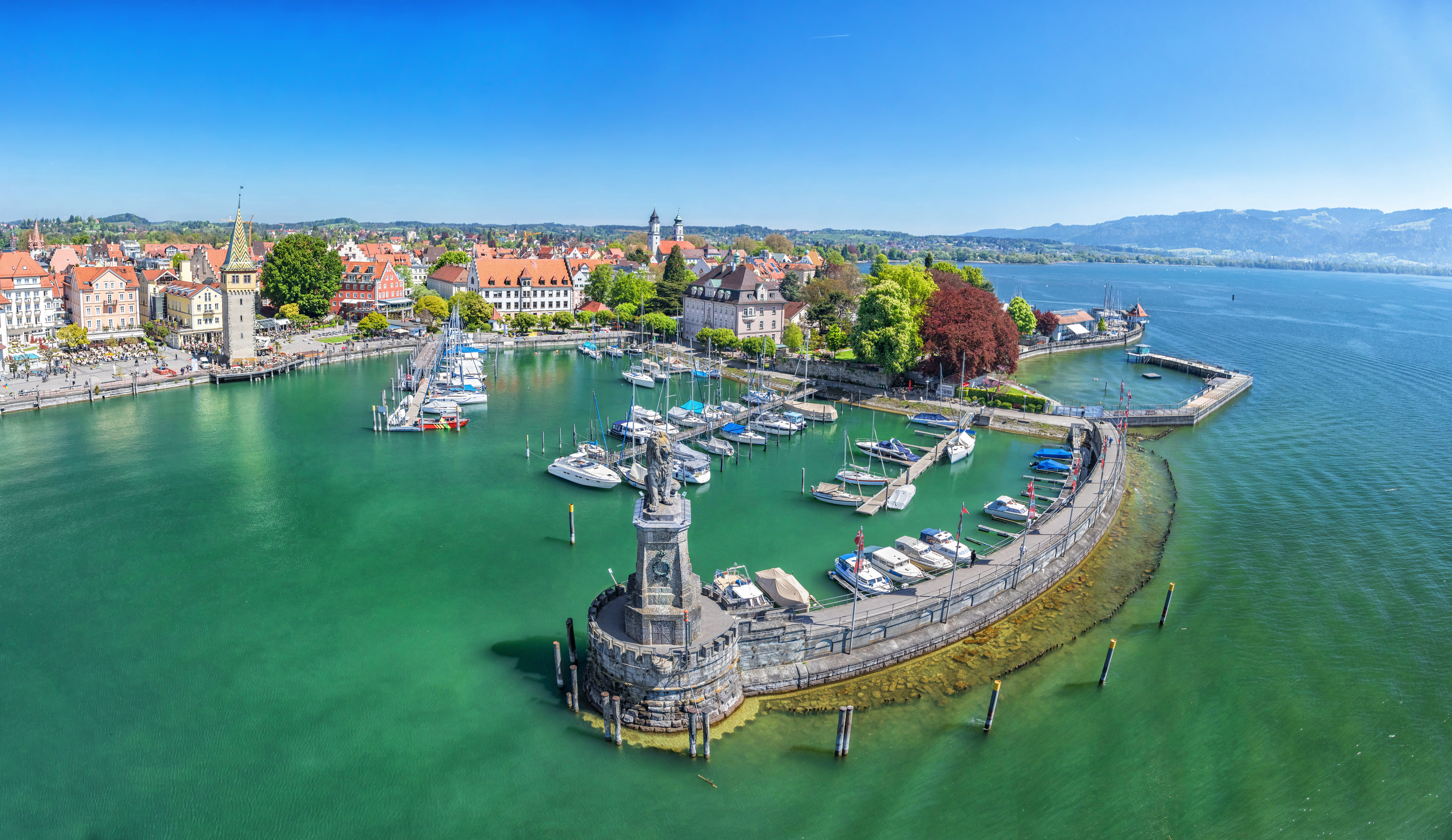 Luftfoto af Lindau fyrtårn og lystbådehavn ved det krystalklare Bodensee