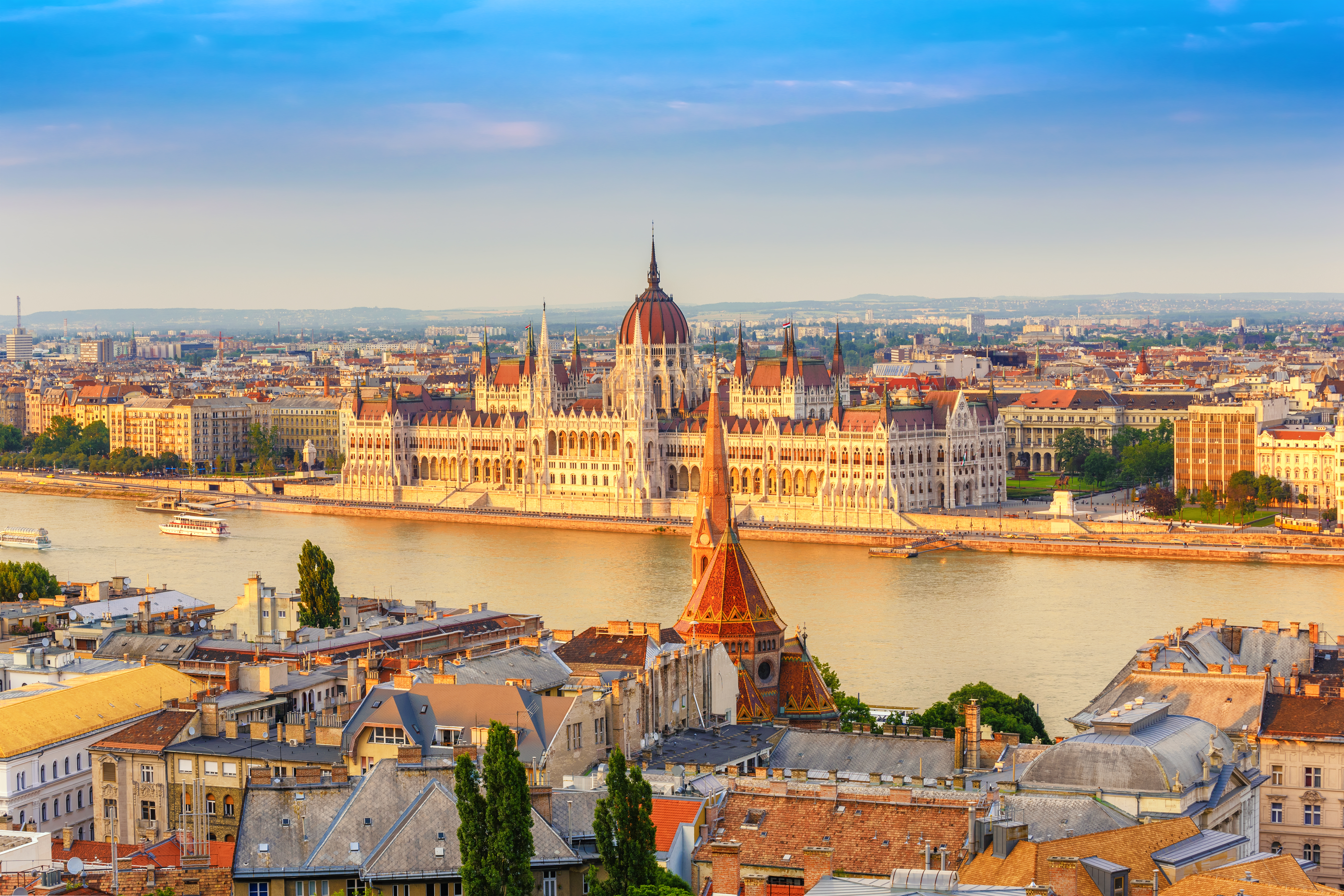 Parlamentsbygningen i Budapest ved Donau med orange tage og blå himmel