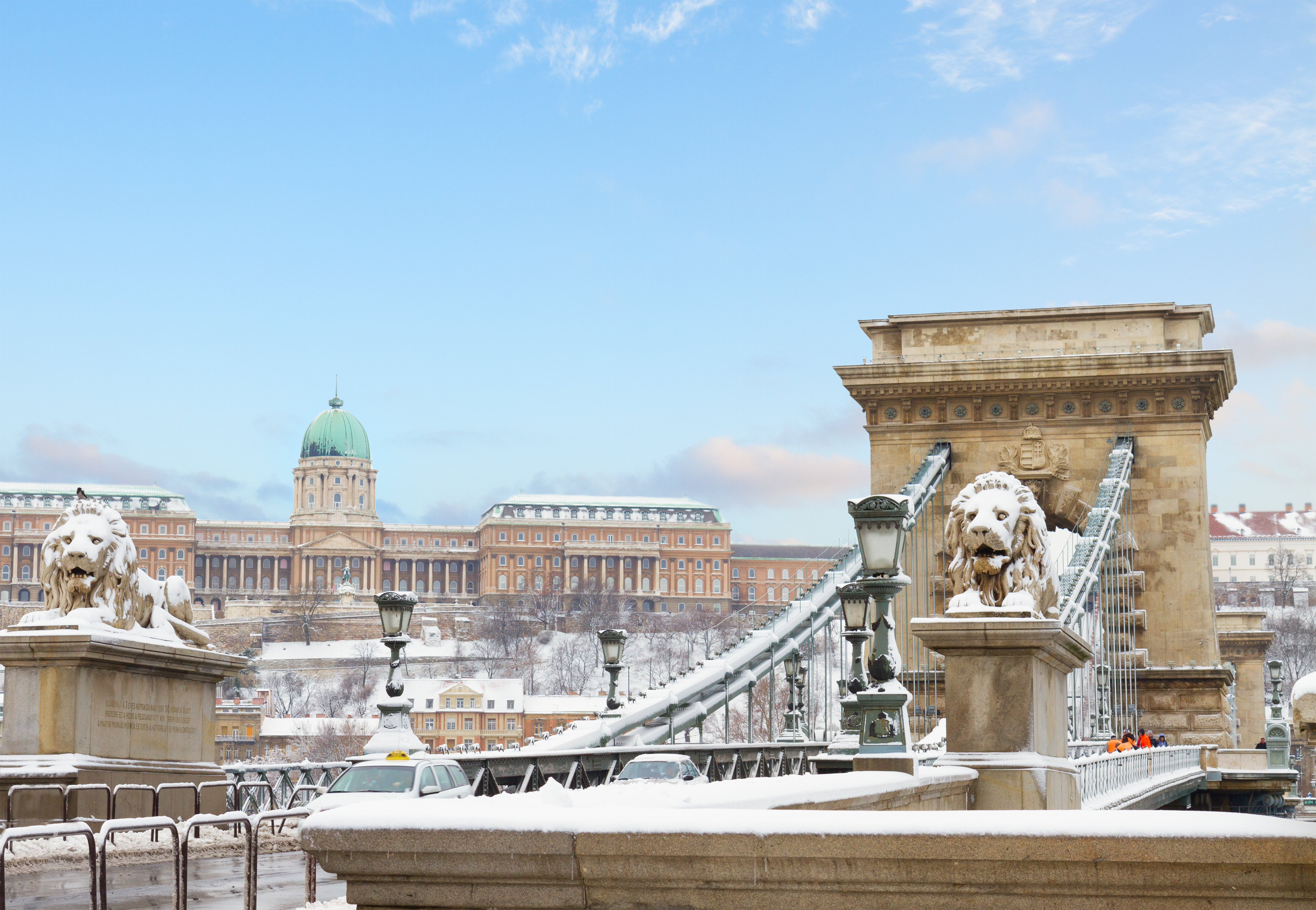 Historisk Chain Bridge i sne med løveskulpturer og udsigt til Buda Castle Budapest