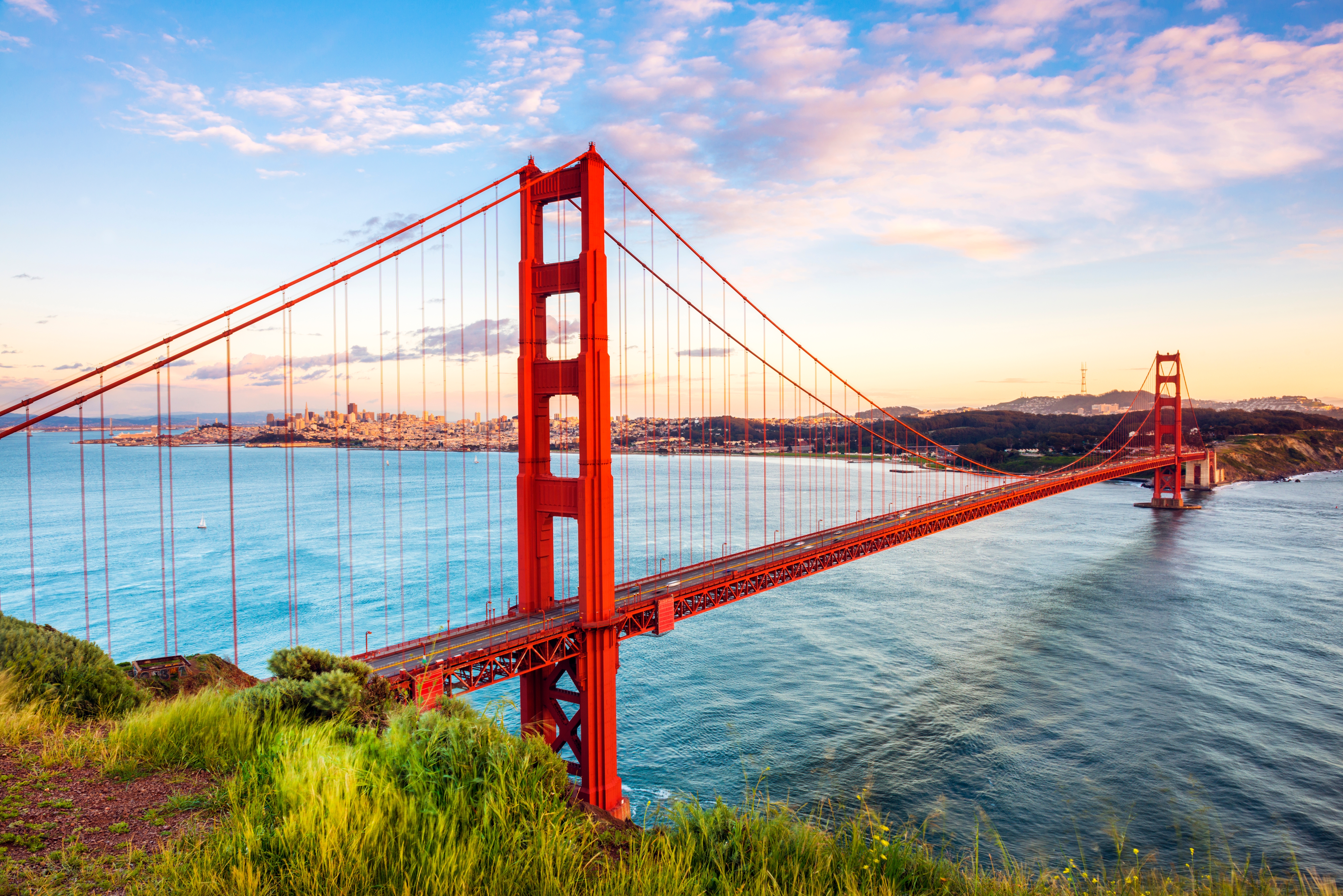 Storslået Golden Gate bro i aftenlys med udsigt over San Francisco bugt og dramatisk himmel