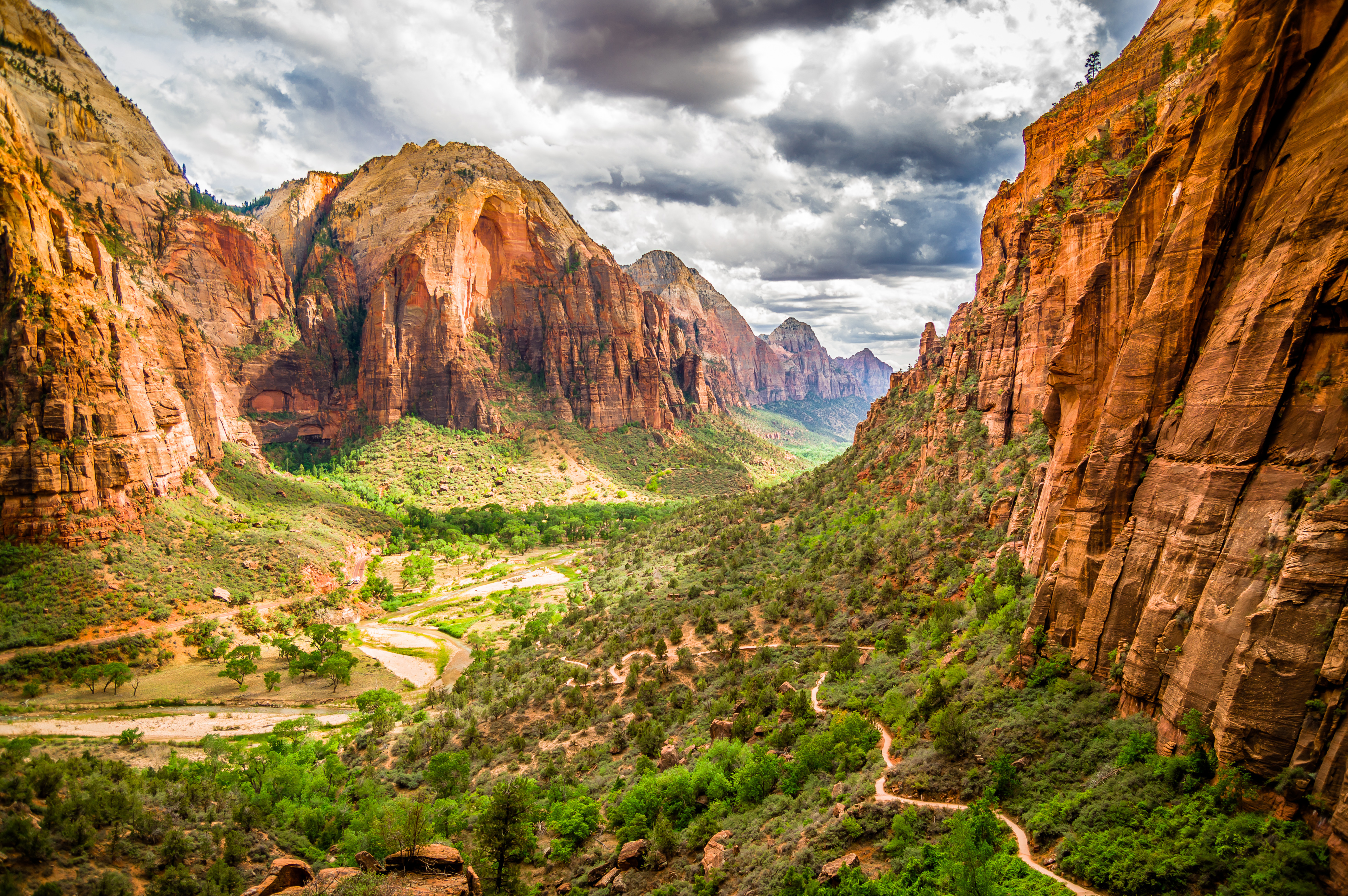 Panoramaudsigt over Zion Canyons imponerende røde klippeformationer og grønne dalbund i Utah