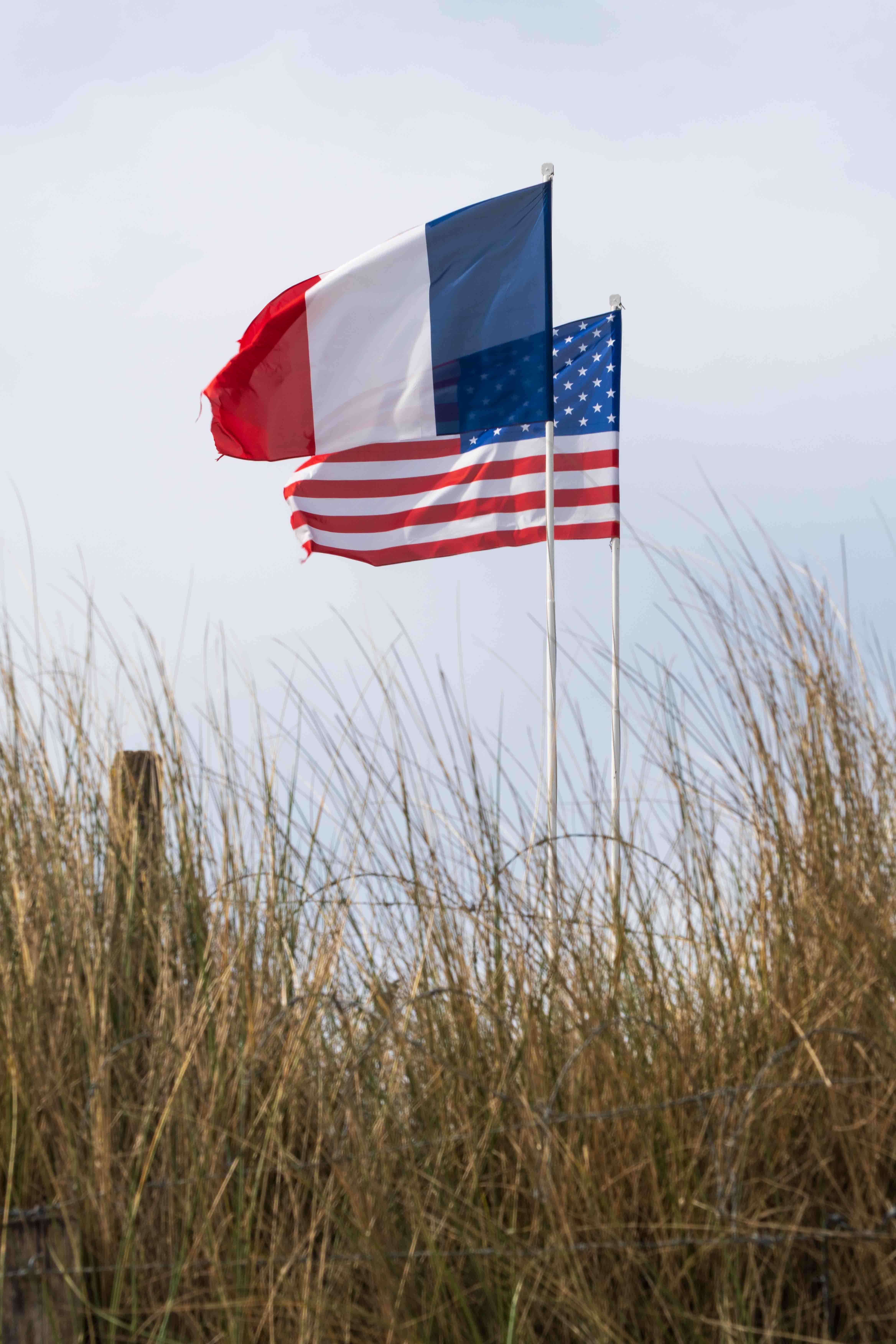 Amerikanske og franske flag på Utah Beach i Normandiet, Frankrig – et historisk mindested for D-dag landgangen under 2. verdenskrig