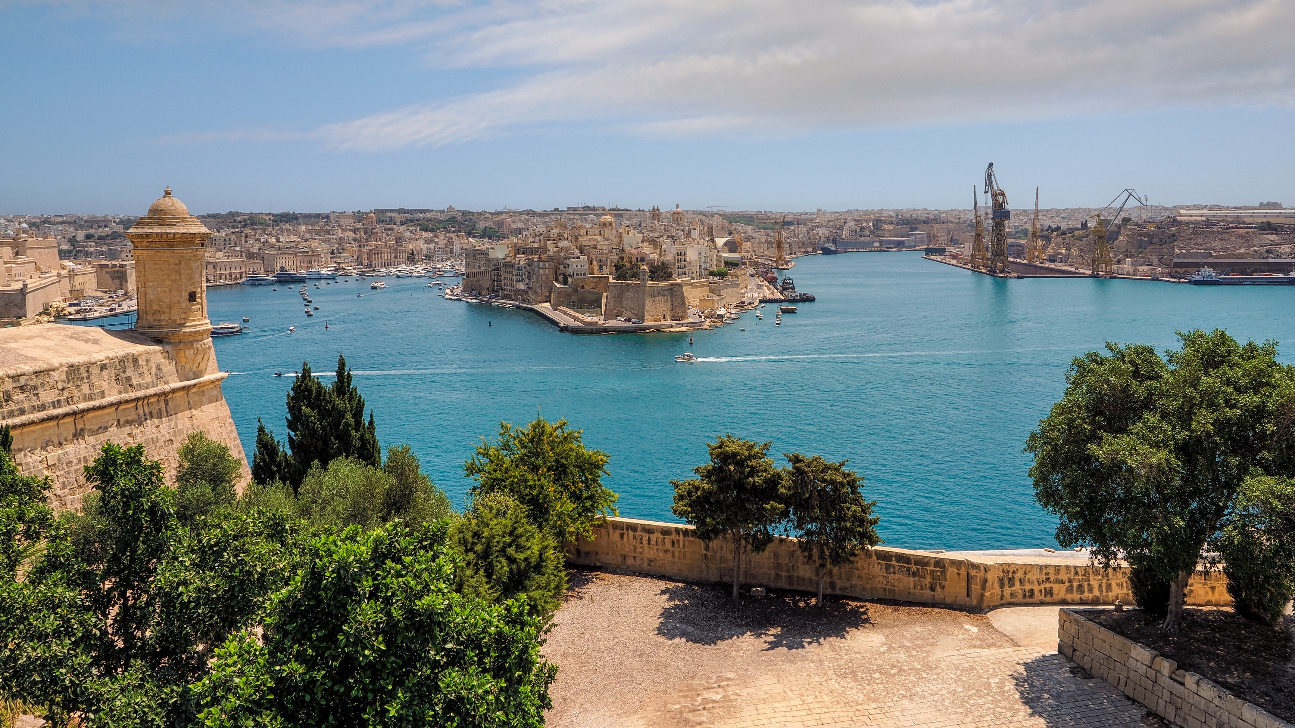 Panoramaudsigt fra Upper Barrakka Gardens i Valletta over Grand Harbour med turkisblåt vand og Maltas historiske fæstningsbyer