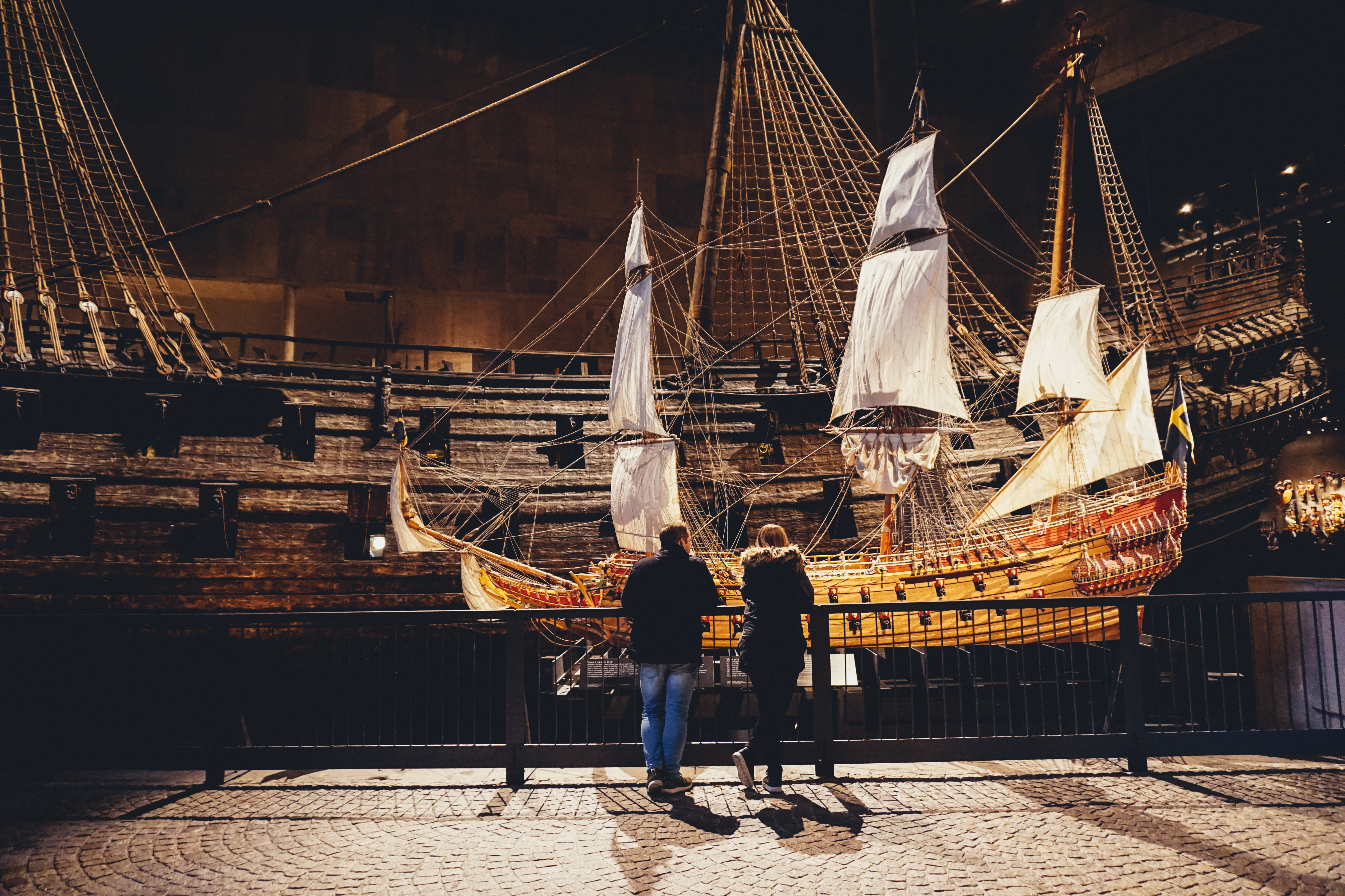 Besøgende beundrer en nøjagtig model af Vasa-skibet på Stockholms verdenskendte Vasamuseet, med det originale 400 år gamle krigsskib i baggrunden