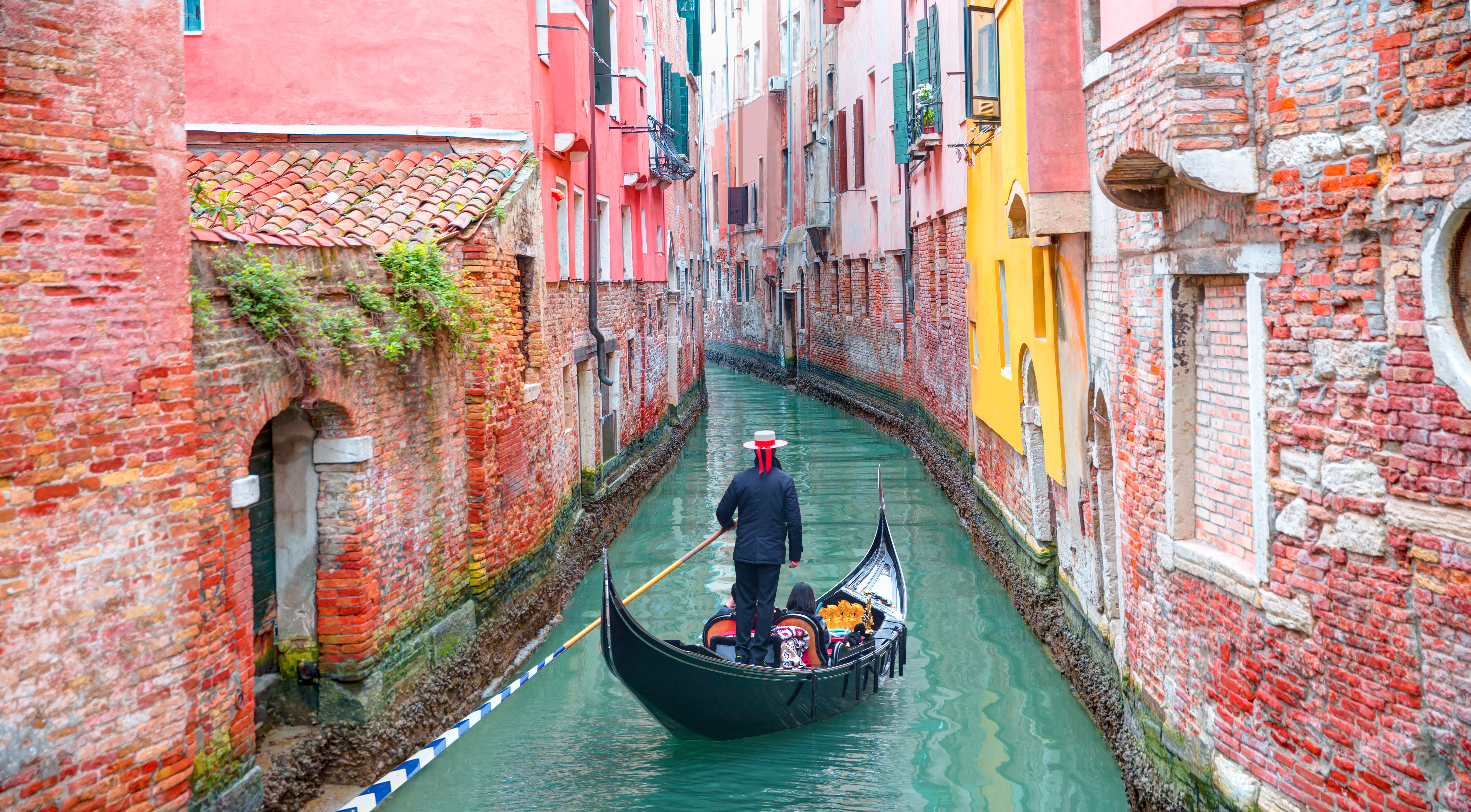 Autentisk gondolbaad sejler gennem historiske kanaler i det romantiske Venedig