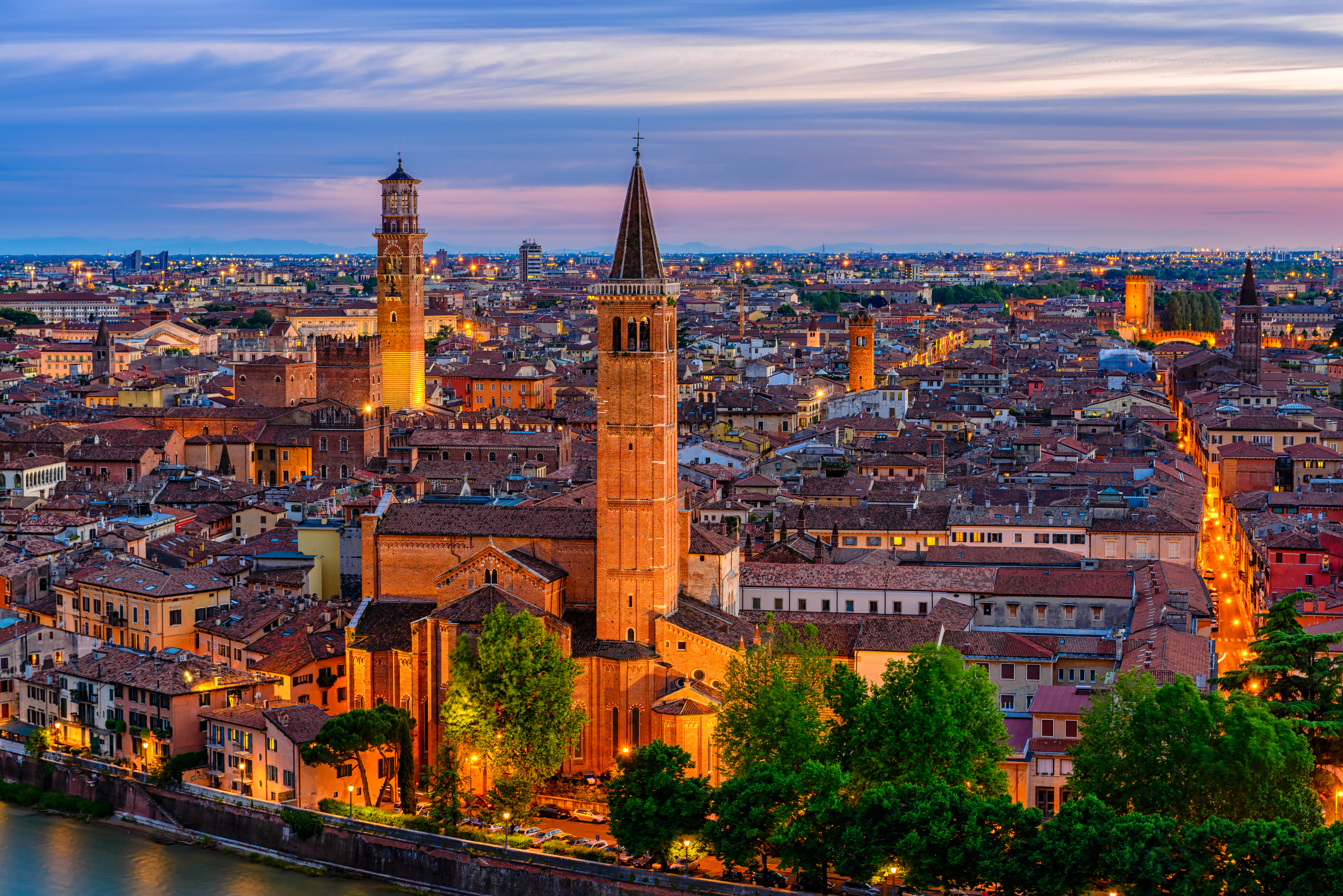 Verona i Italien ved aftentide med oplyst Torre dei Lamberti og historisk bybillede