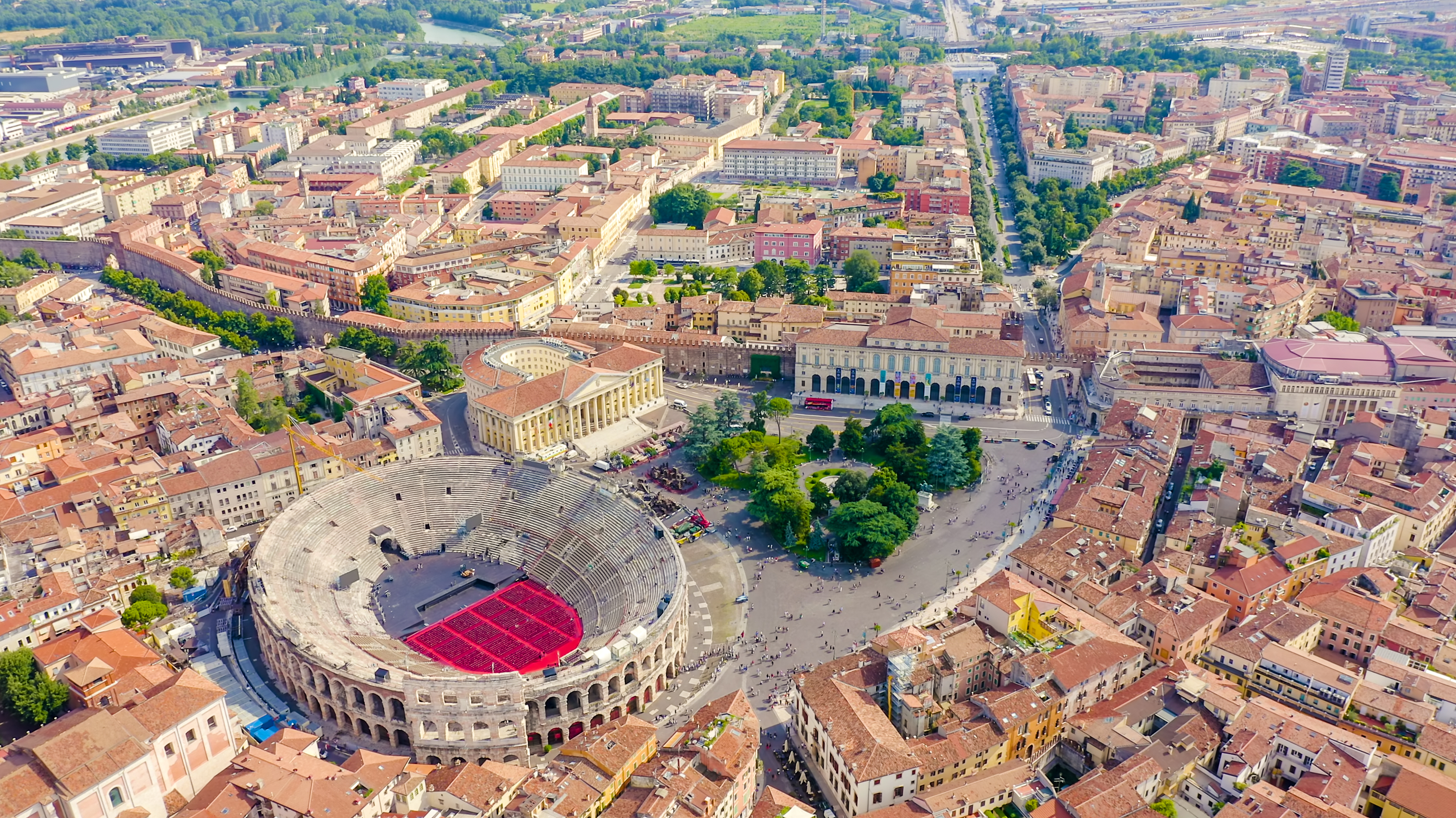 Panoramaudsigt over Verona fra luften med det ikoniske Arena di Verona amfiteater omgivet af den maleriske gamle bydel med røde tage