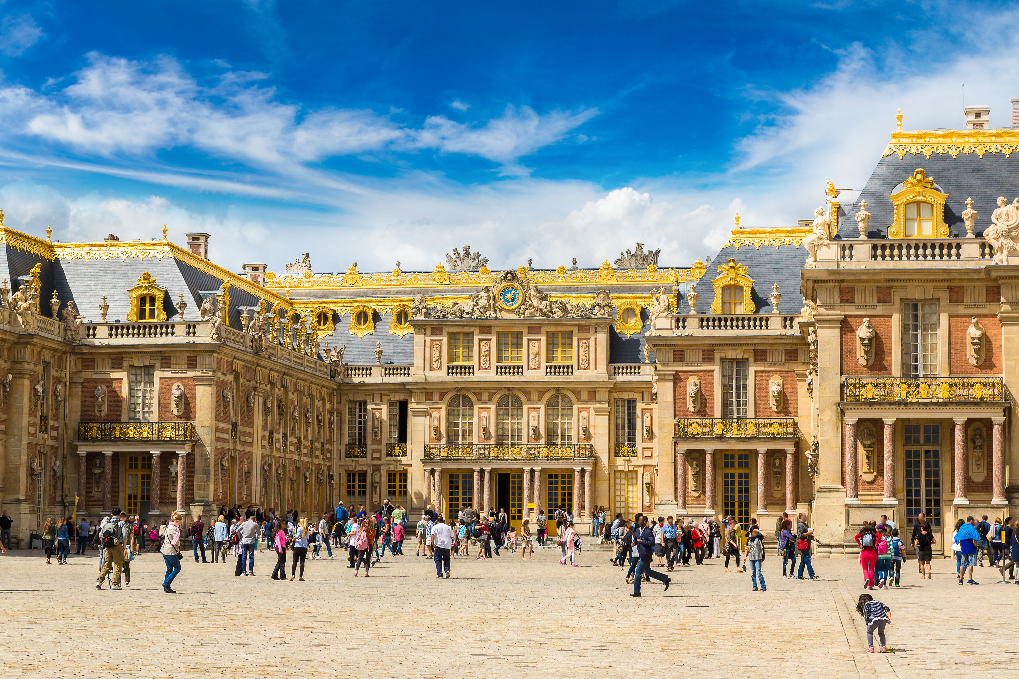 Versailles slotsgård i Frankrig om sommeren med historisk arkitektur og mange turister