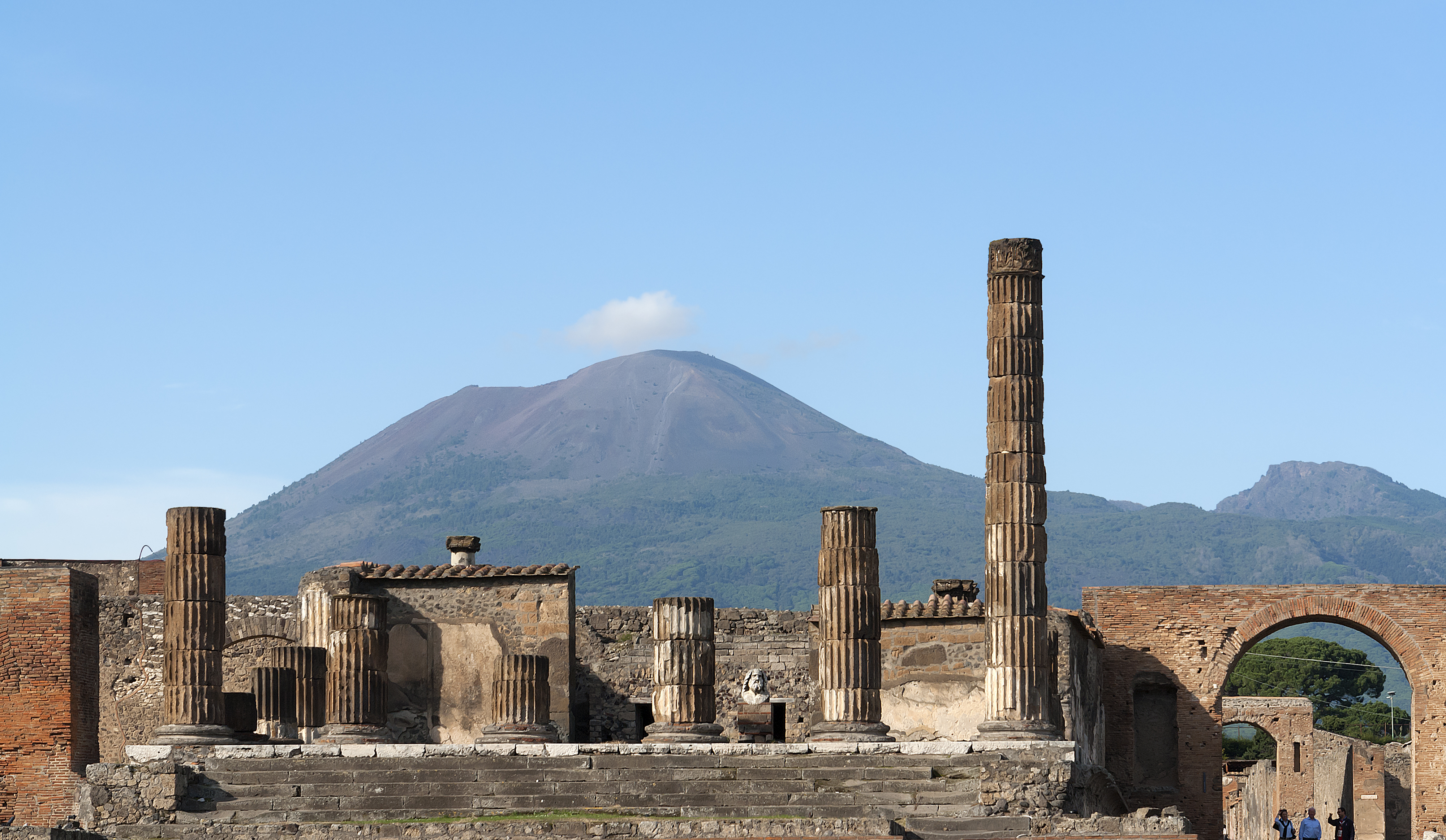 De betagende ruiner af den antikke romerske by Pompeji med de karakteristiske søjler i forgrunden og den berømte vulkan Vesuv, der ødelagde byen ved et udbrud i år 79, i baggrunden nær Napoli