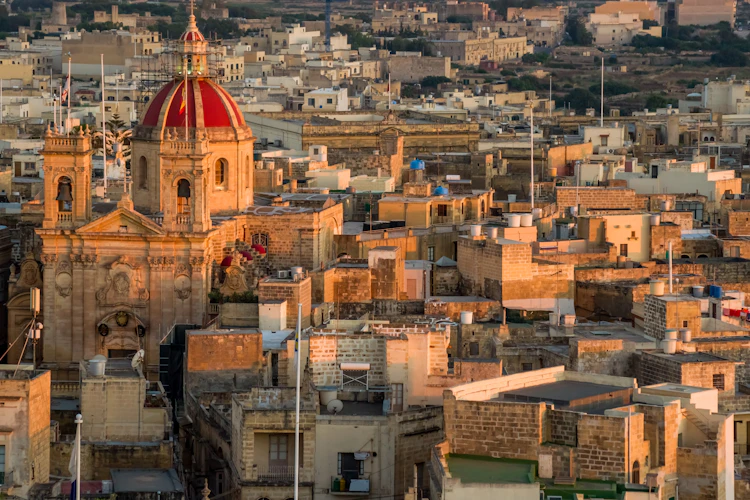 Fantastisk udsigt over den historiske by Victoria på Gozo med den imponerende katedral og de varme okkerfarvede tage i solnedgangslys