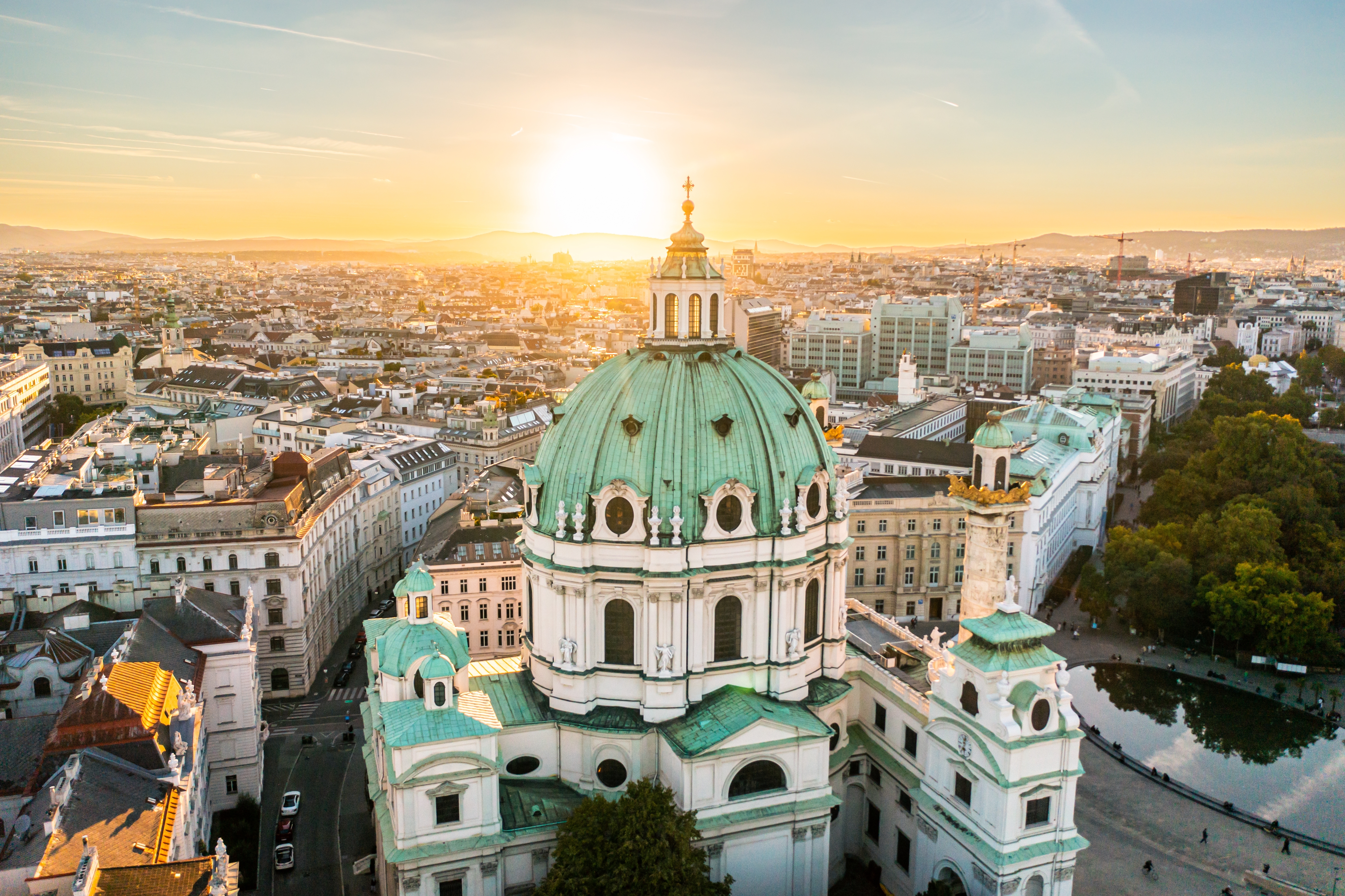 Luftfoto af St. Charles Church i Wien ved solnedgang, der fremhæver den historiske arkitektur.