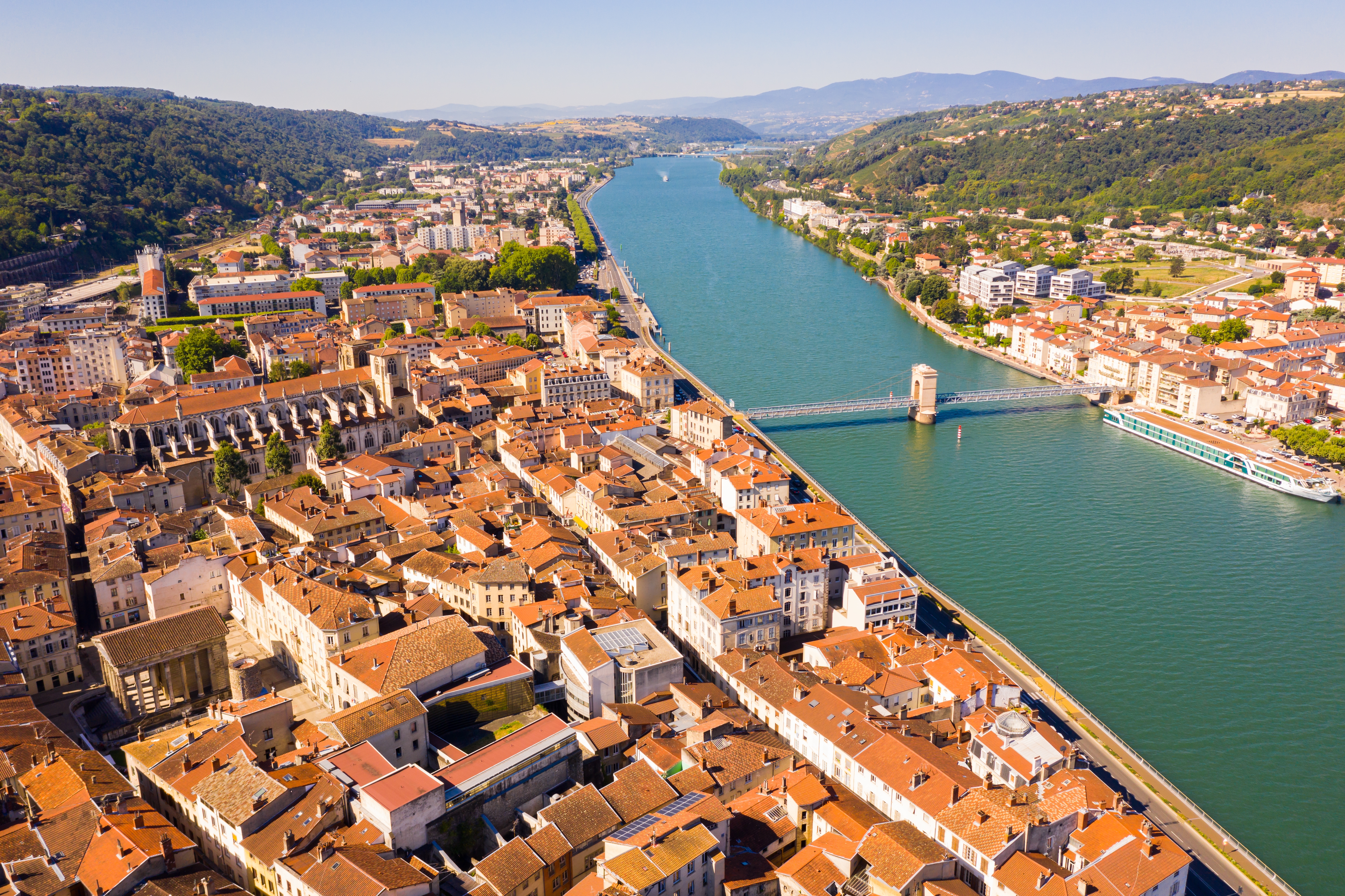 Smuk luftudsigt over Vienne ved Rhône-floden i det sydøstlige Frankrig med historisk bymidte, hængebro og grønne bakker