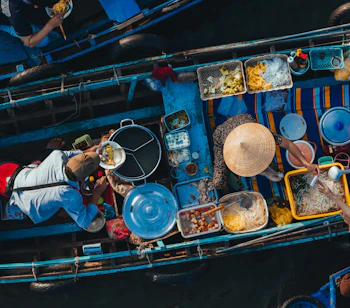 Luftfoto af det farverige flydende marked Cai Rang i Can Tho på Mekong Delta i Vietnam, hvor lokale sælger frisk mad fra traditionelle træbåde