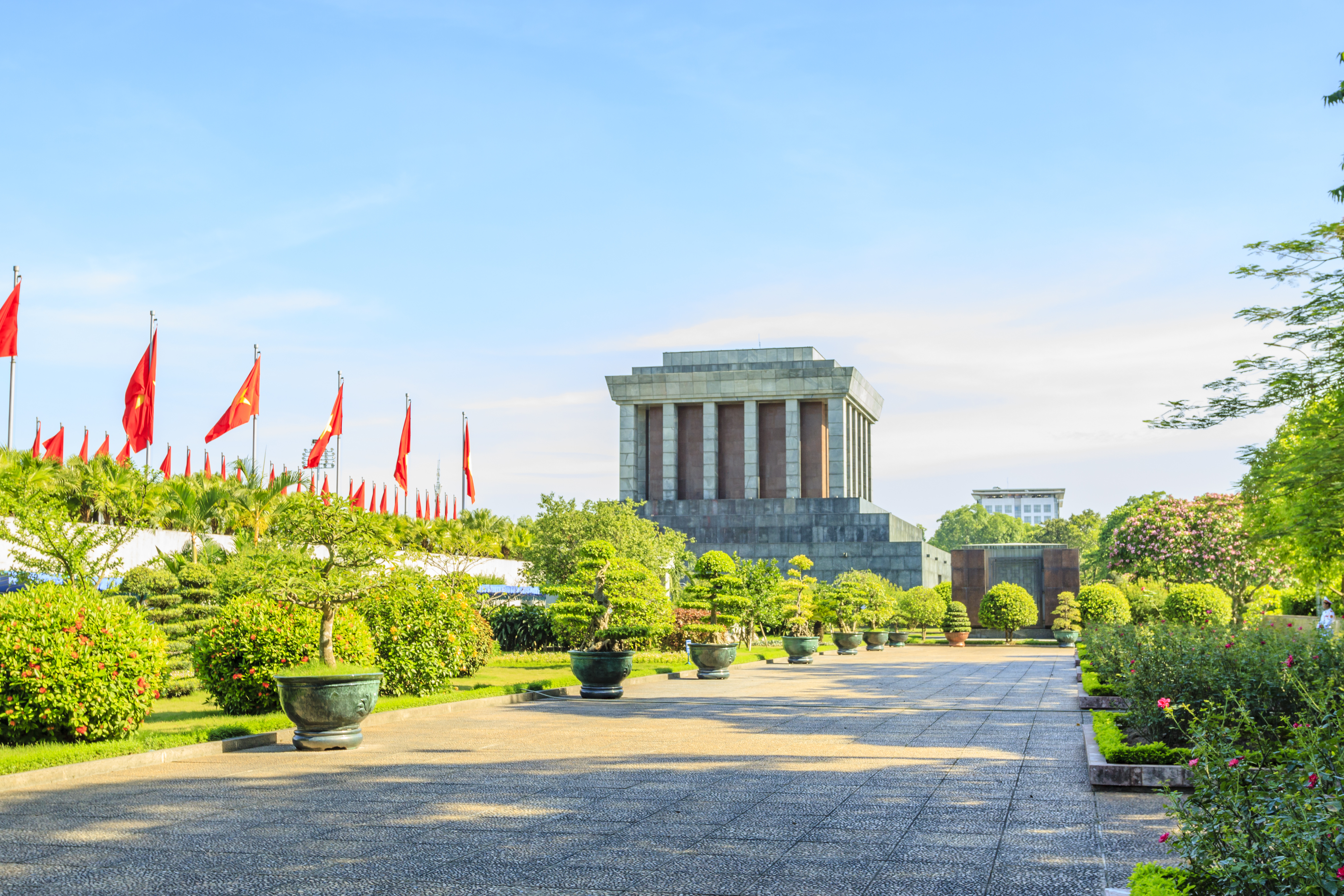 Monumentalt mausoleum i Hanoi omgivet af flag og velplejet have