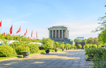 Monumentalt mausoleum i Hanoi omgivet af flag og velplejet have