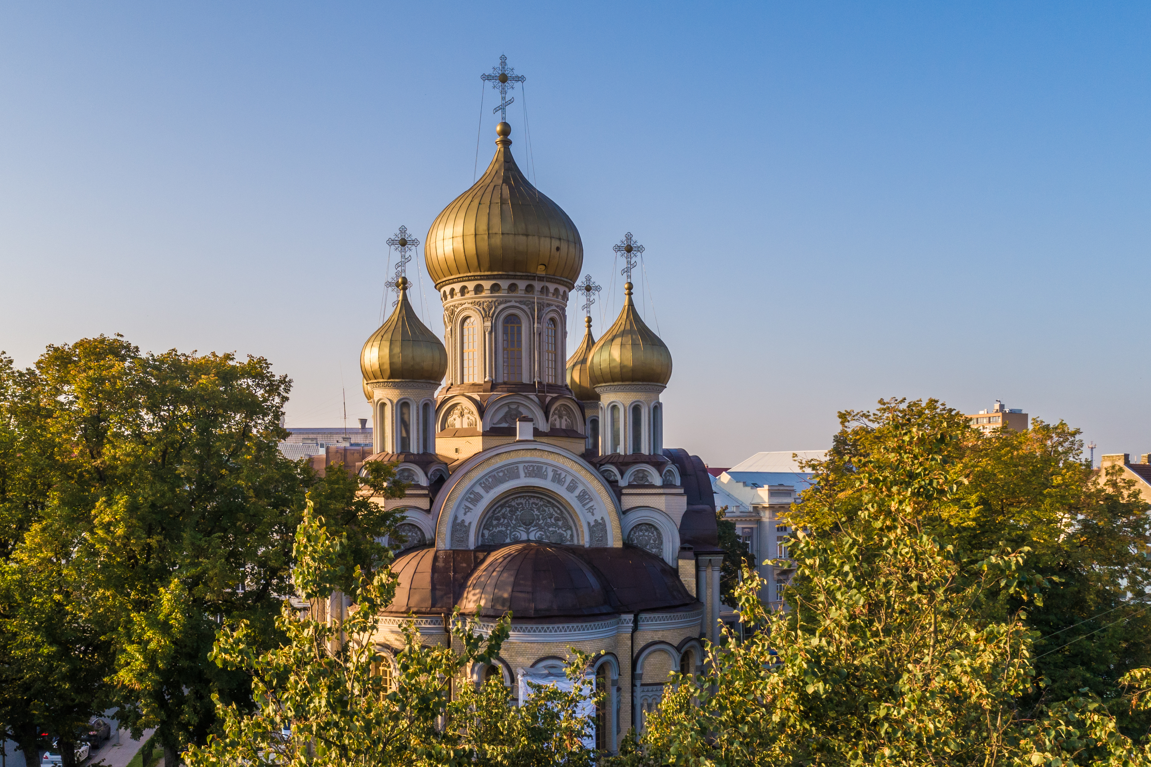 Dramatisk luftfoto af den ortodokse Romanov-kirke med forgyldte kupler badet i det gyldne morgenlys i hjertet af Vilnius' historiske centrum i Litauen