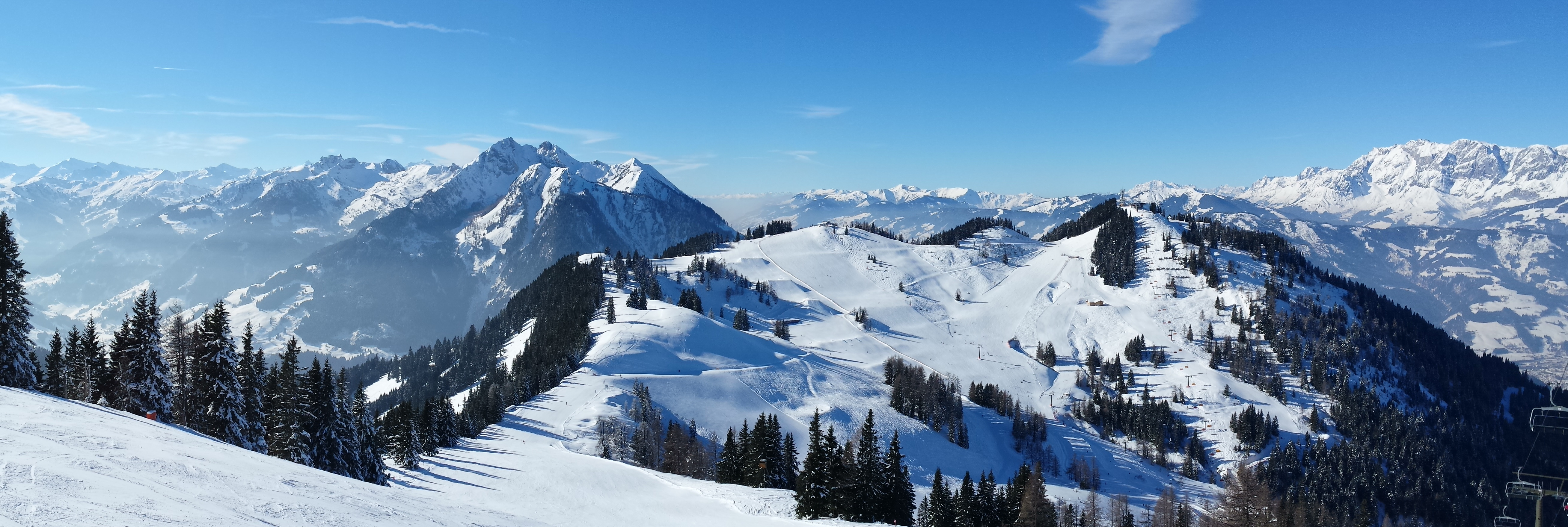 Fantastisk panoramaudsigt over det snedækkede bjerglandskab i Flachau, Østrig, hvor de majestætiske alper skaber ideelle forhold for skientusiaster under den klare vinterhimmel