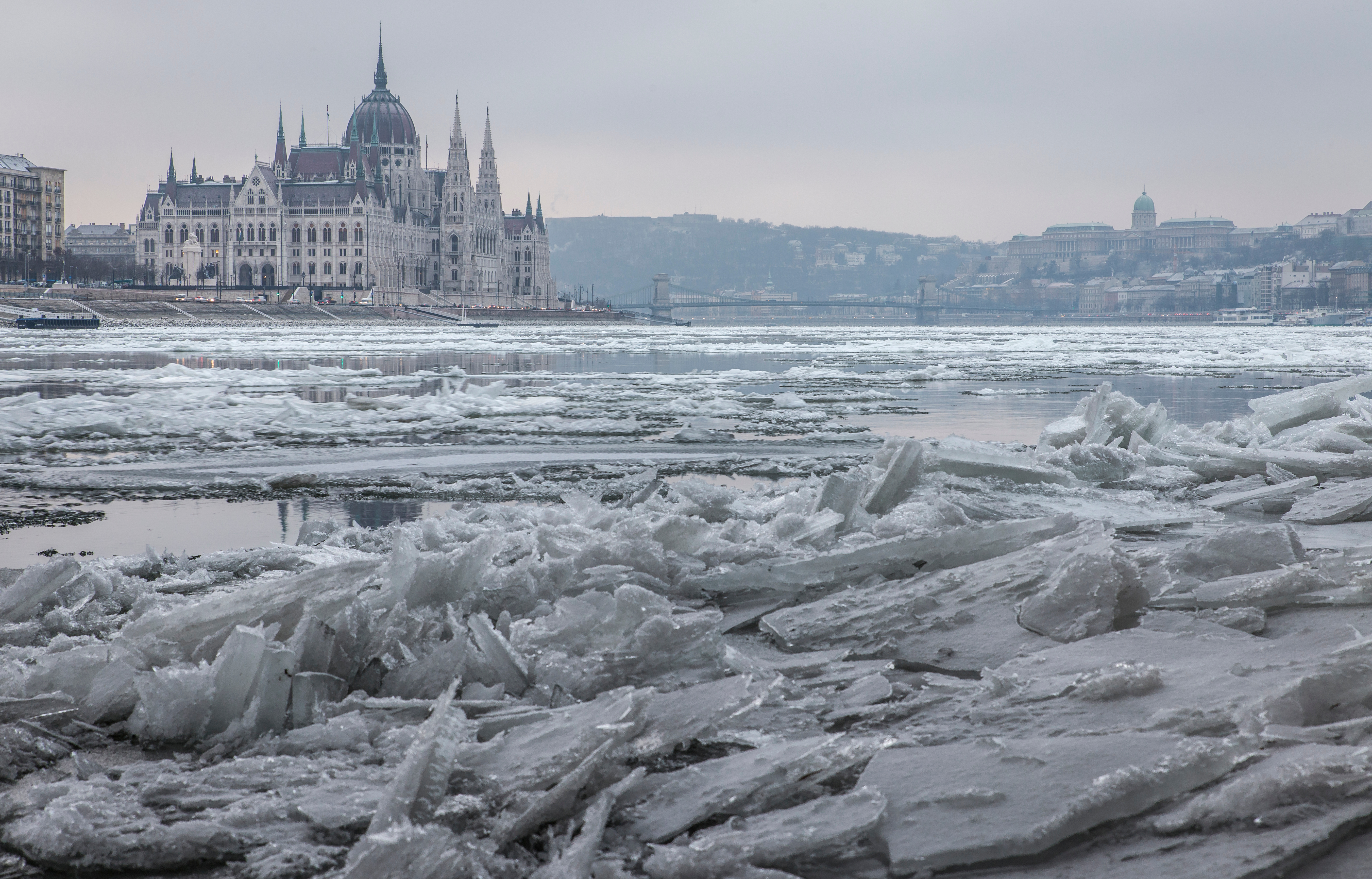Spektkulær vinterudsigt over det tilfrosne Donau og ungarske parlament