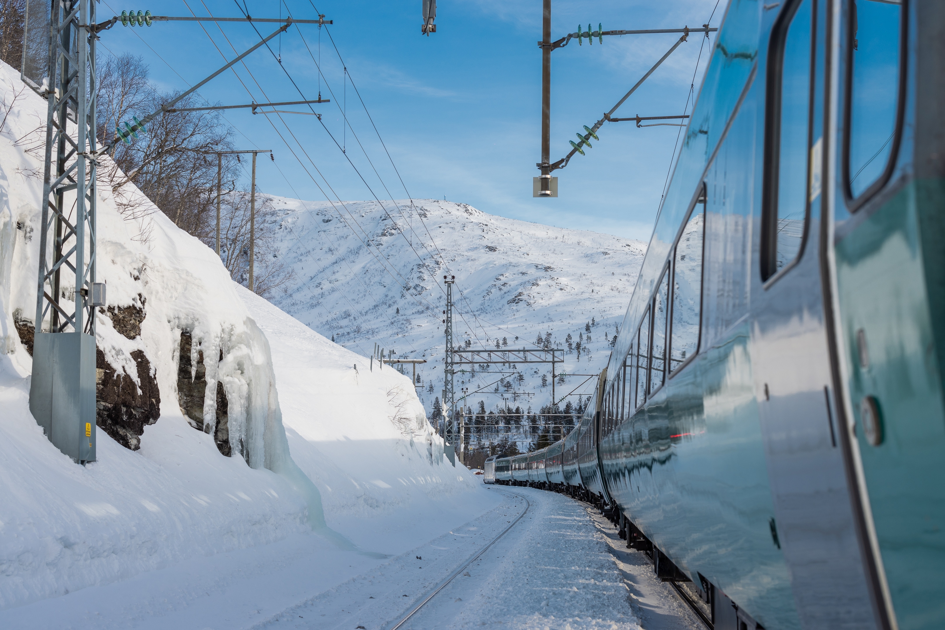 Norges smukke vinterbane med tog kørende gennem snedækte dale