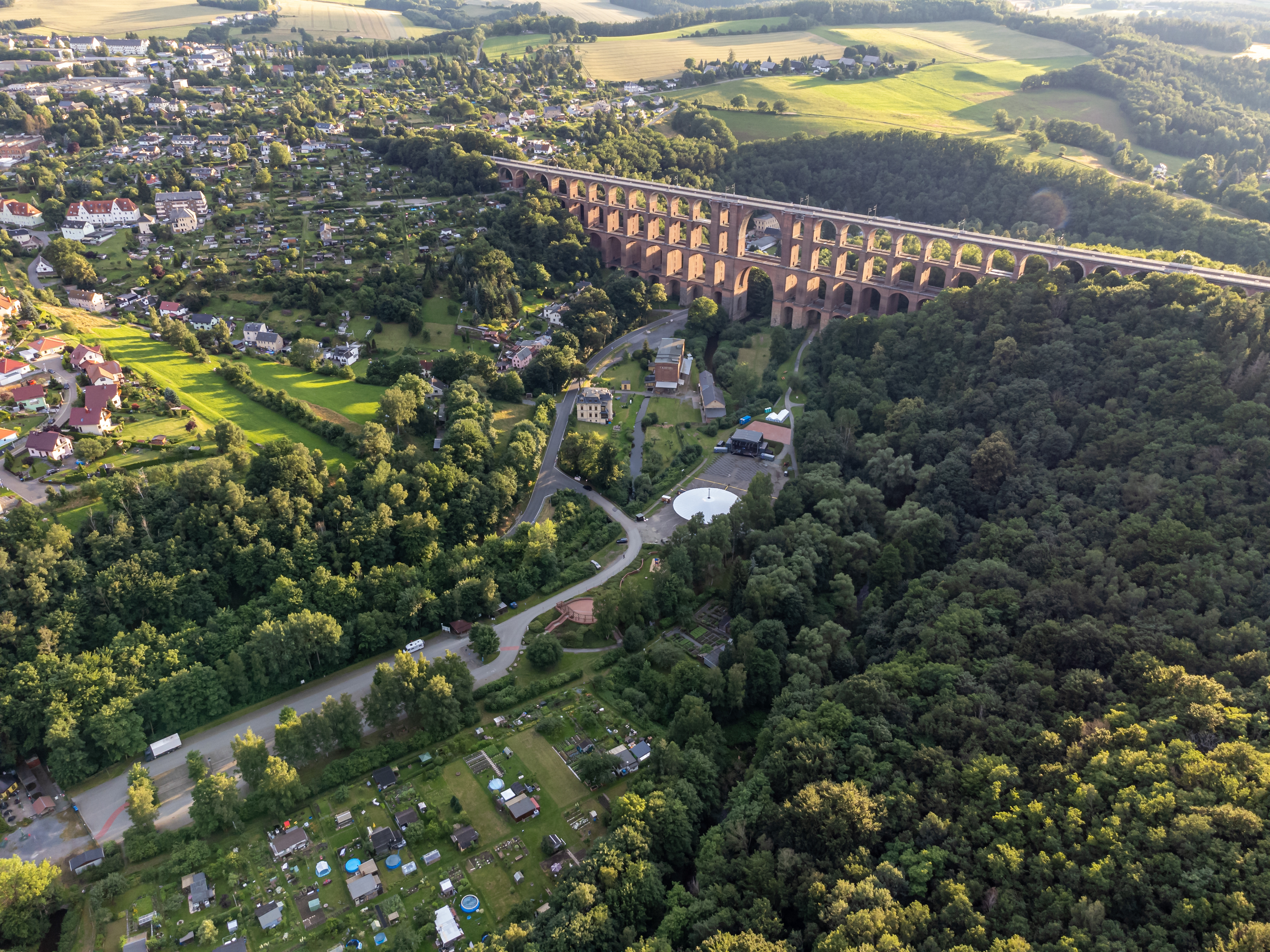 Fugleperspektiv over den storslåede Göltzschtal-jernbaneviadukt i Vogtland – en historisk murstenbro omgivet af grønne skove i det sydlige Tyskland