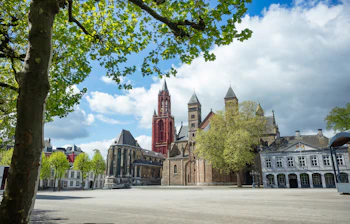 Den brede Vrijthof-plads i Maastricht med det karakteristiske røde kirketårn og historiske bygninger i foråret
