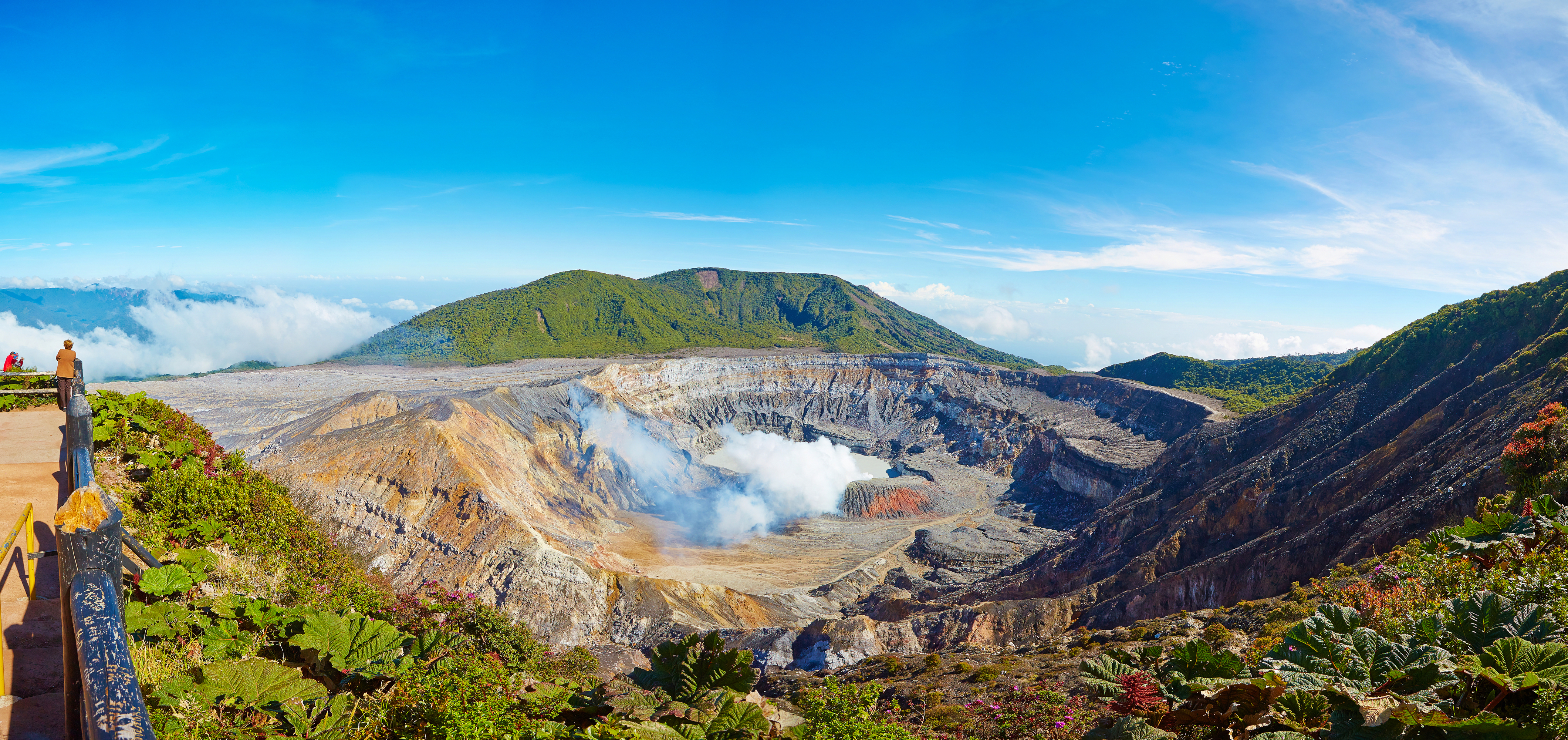 Imponerende vulkankrater med røg og grøn vegetation i Costa Rica
