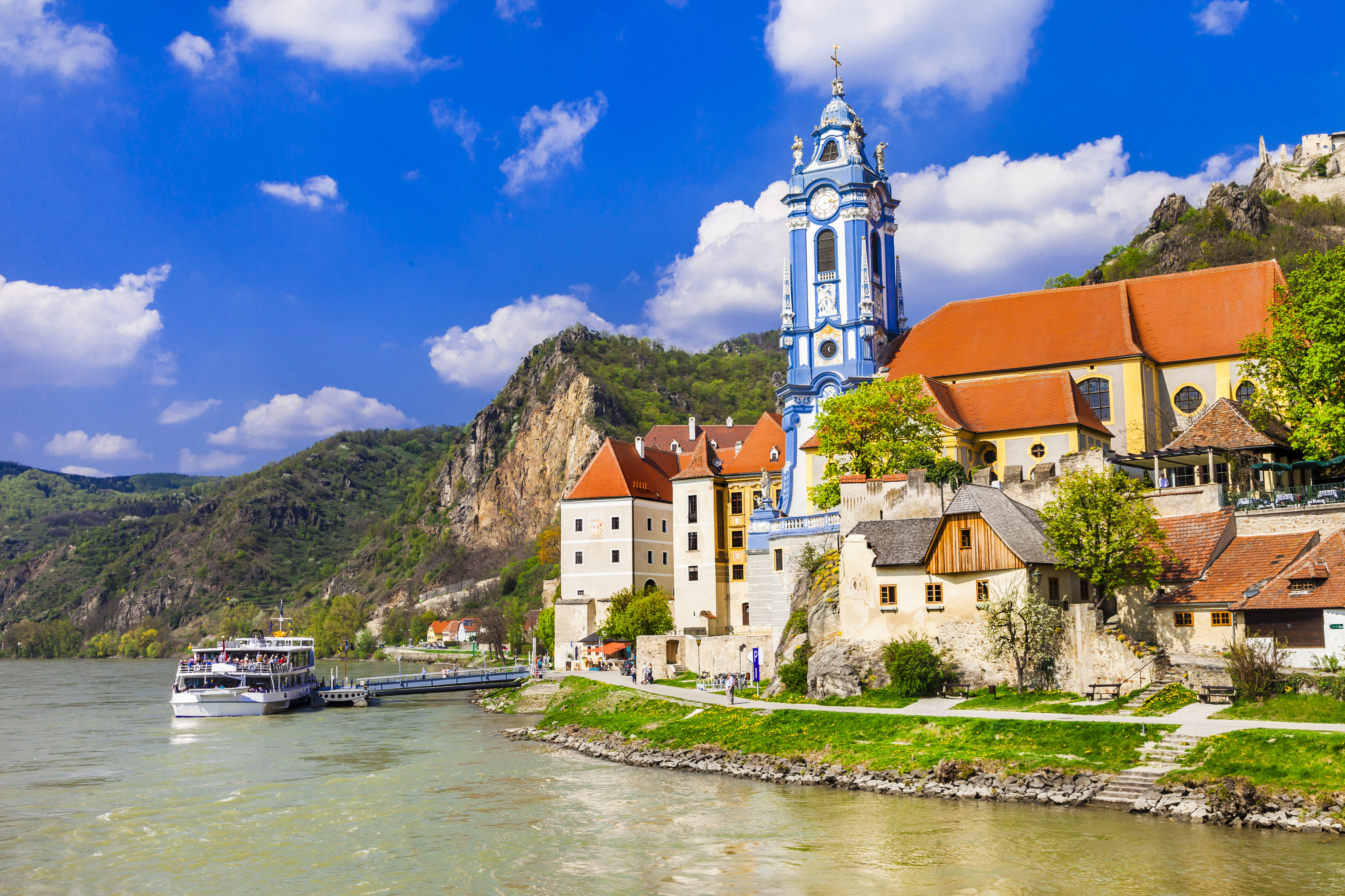 Wachau-dal ved Donau med klosterkirke og middelalderlige huse langs floden med passagerbåd