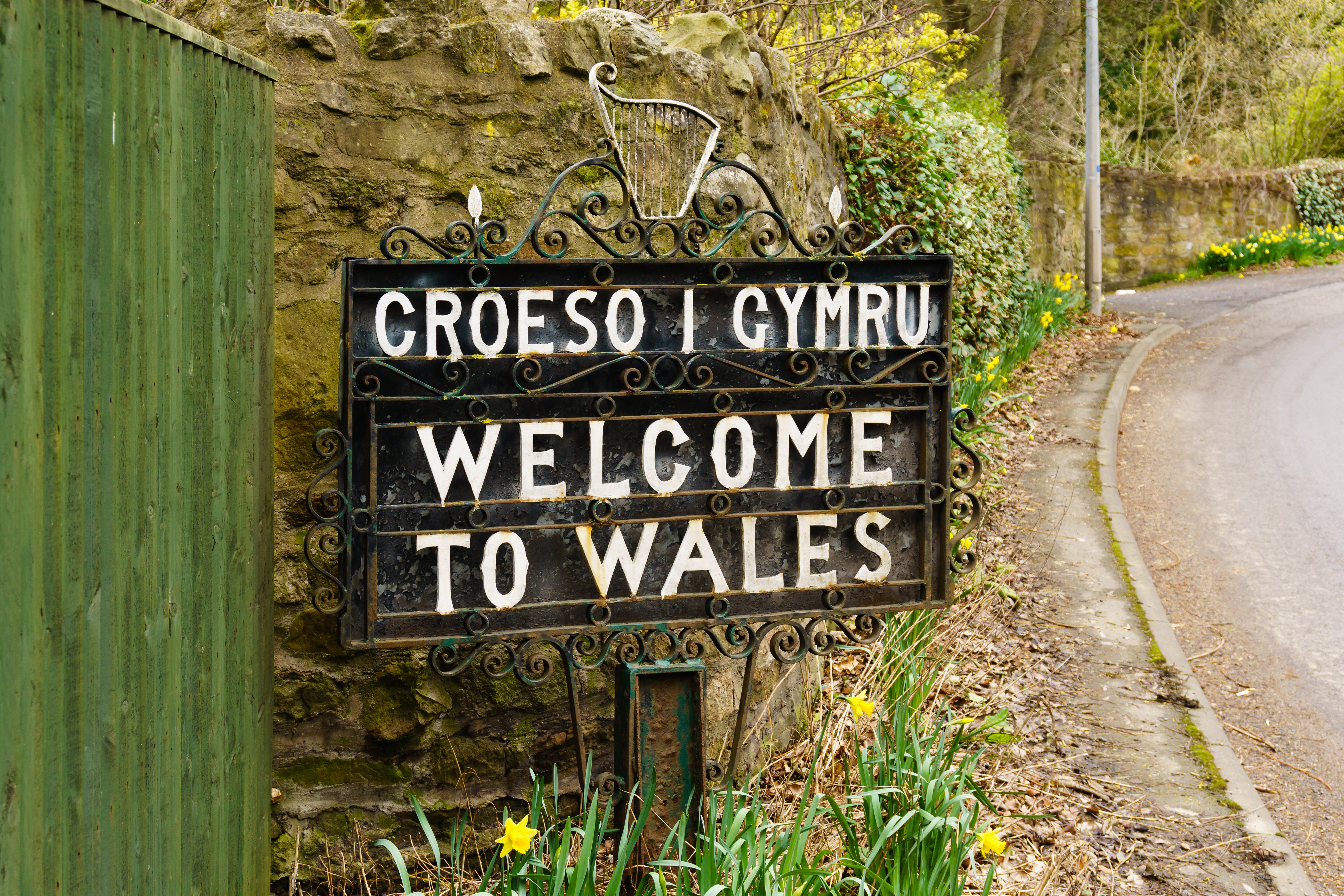 Tosproget skilt ved grænsen mellem England og Wales nær Chirk by, der byder rejsende velkommen på den gamle historiske landevej