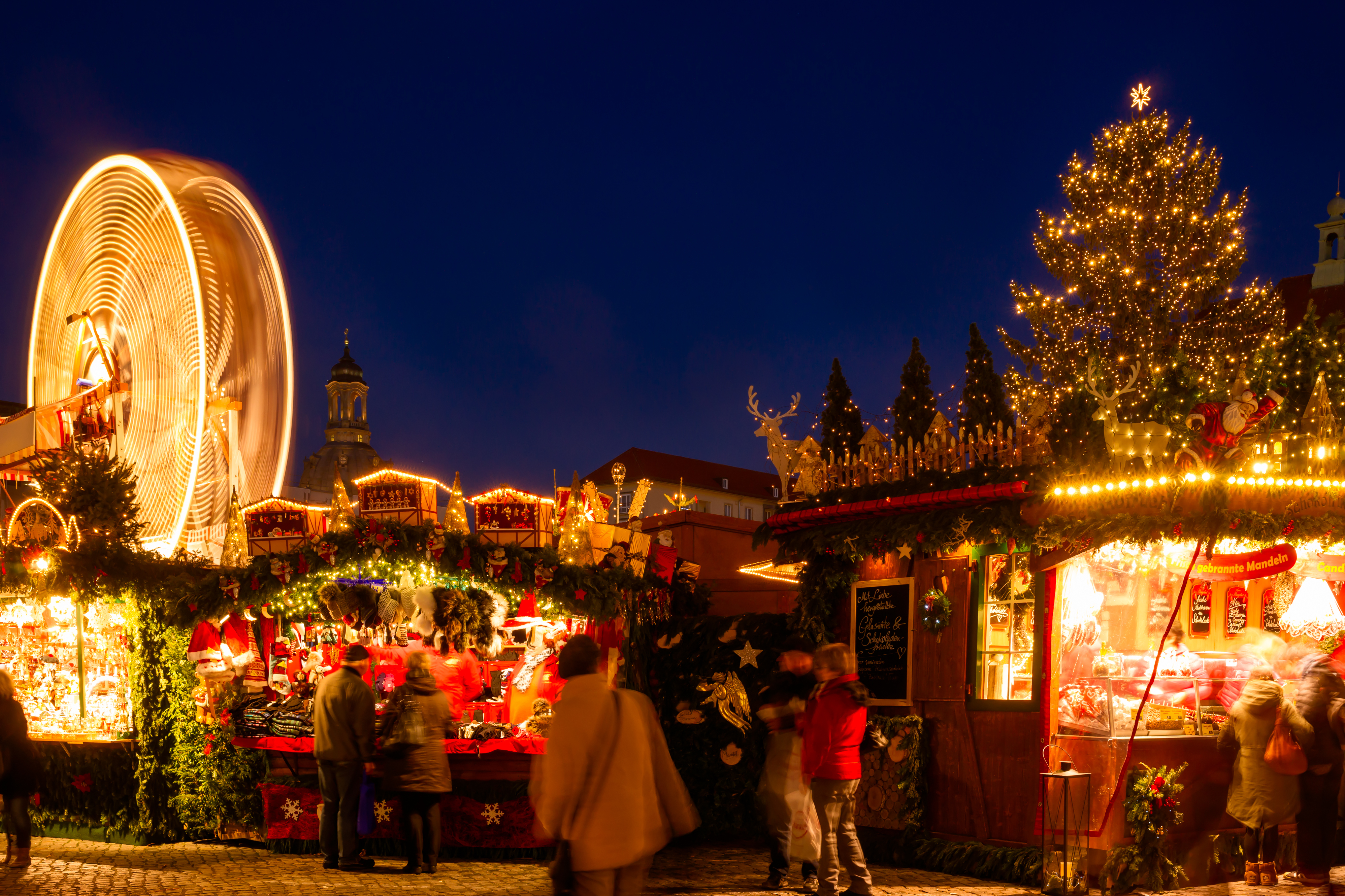Autentisk tysk weihnachtsmarkt med karrusel og festlig belysning om aftenen