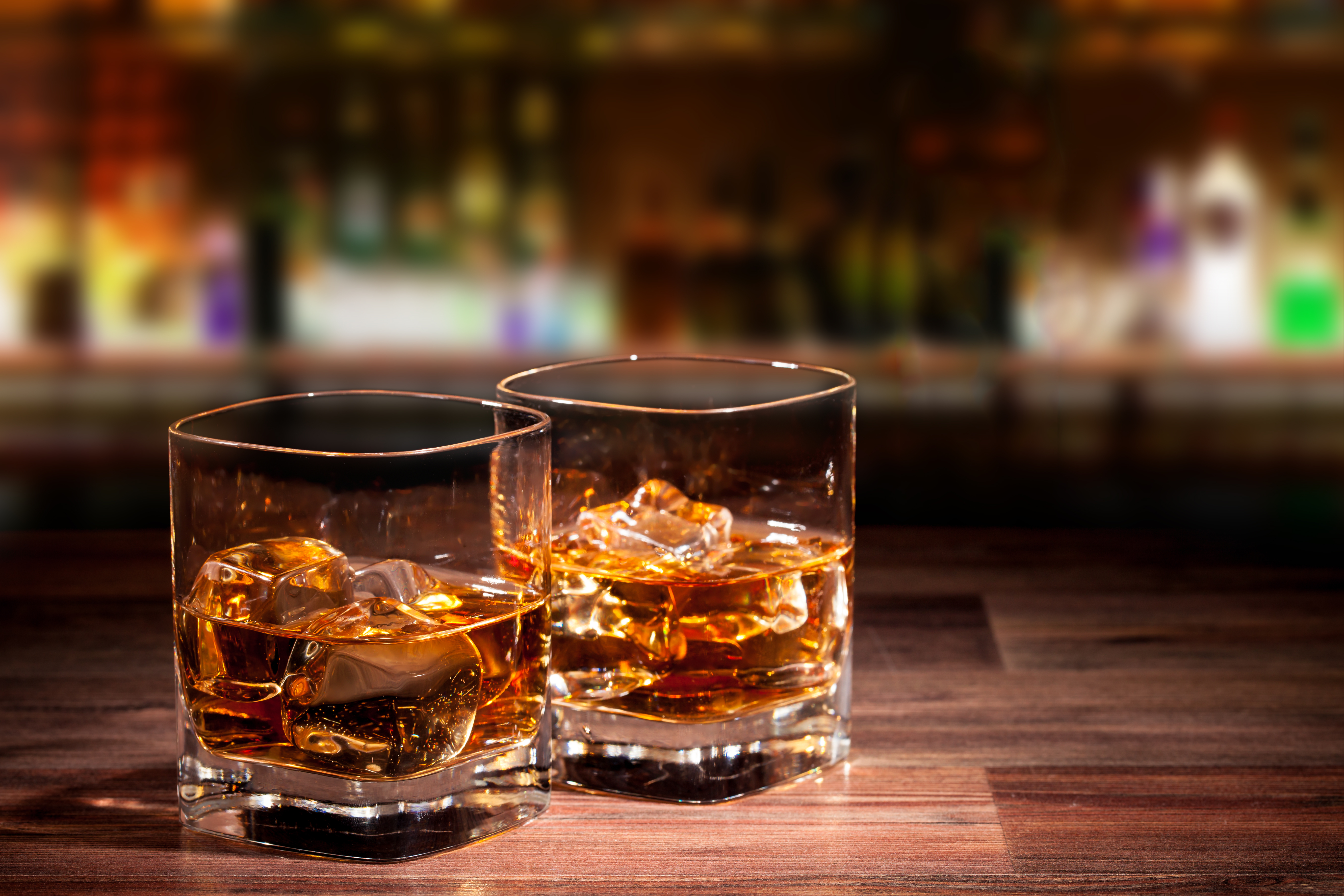 To glas kold whisky med isterninger serveret i en klassisk bar på rejsen