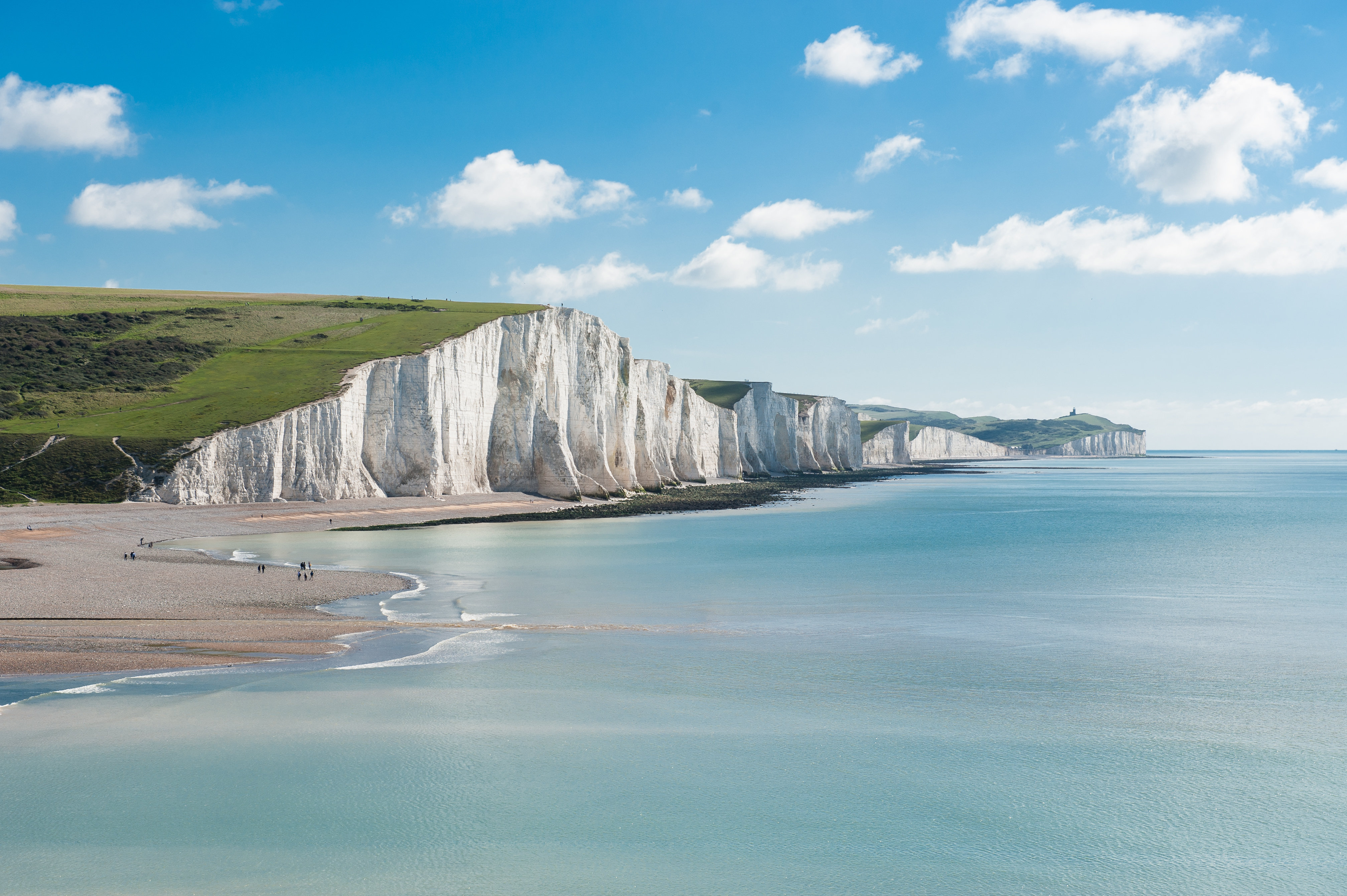 Betagende udsigt over de hvide klinter ved Seven Sisters i East Sussex med azurblåt hav og grønne bakketop