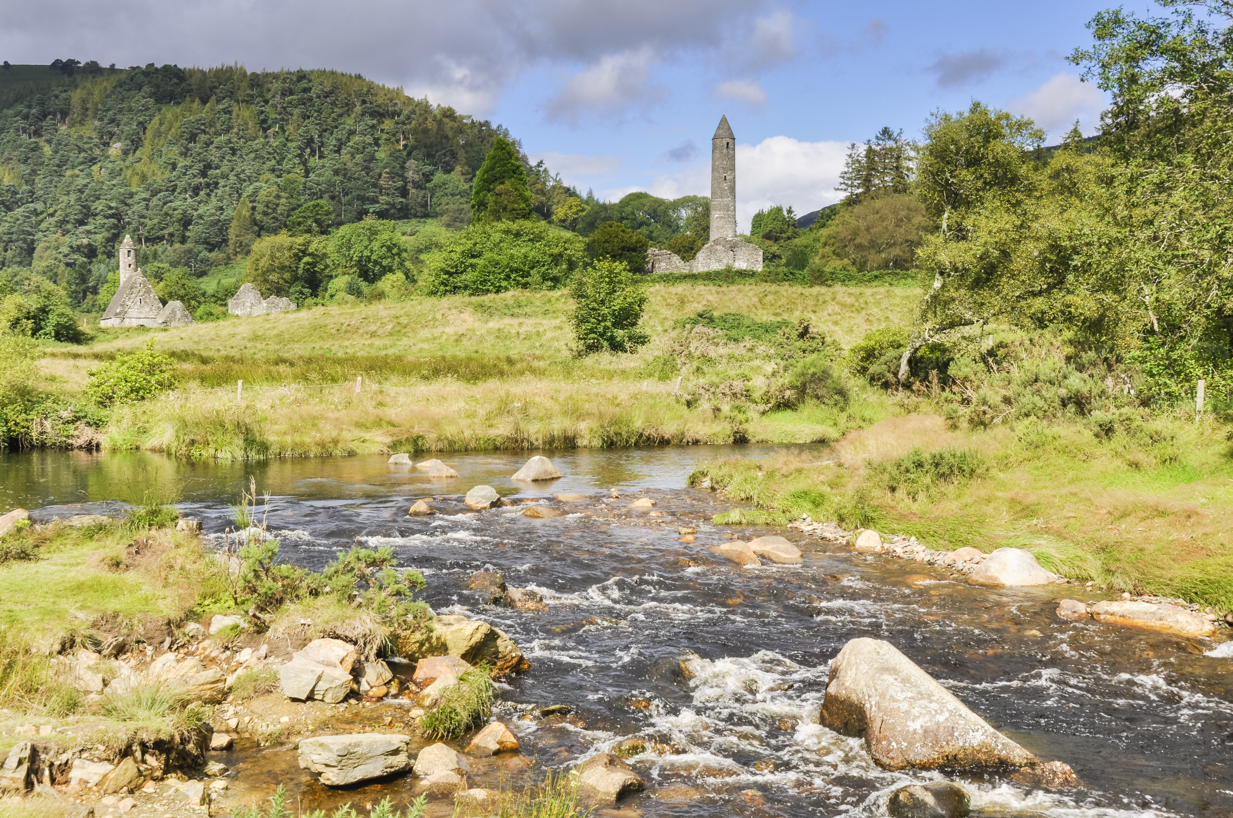 Det smukke Glendalough klosteranlæg i Wicklow Mountains, Irland, med det karakteristiske keltiske rundtårn og ruiner af gamle kirker spejlet i den klare bjergelv