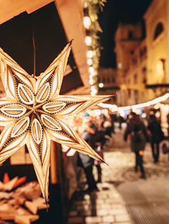 Gylden stjerne på adventmarked i Wien med varmt lys og julehandlende