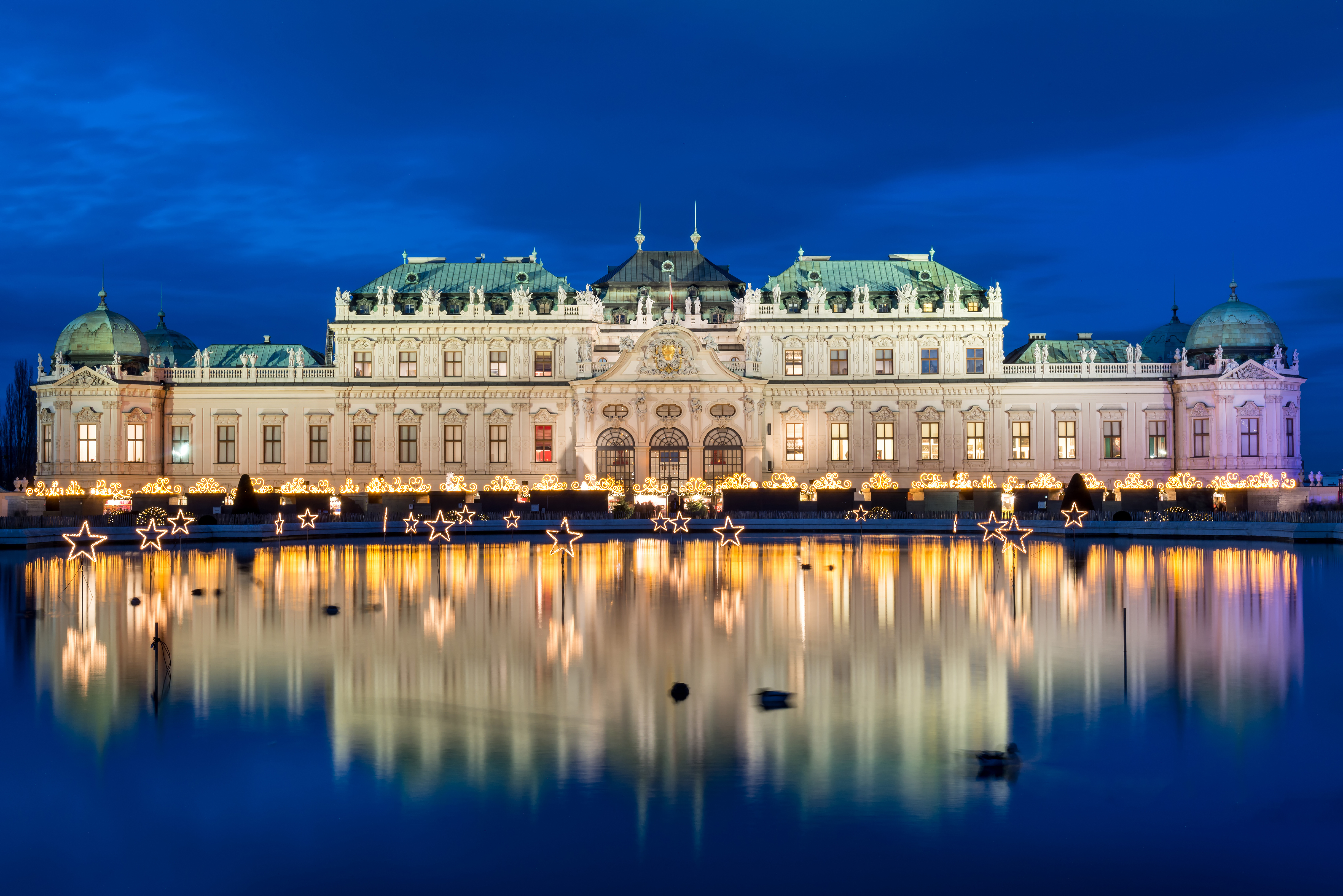 Belvedere i Wien om aftenen med julelys og spejling i vand