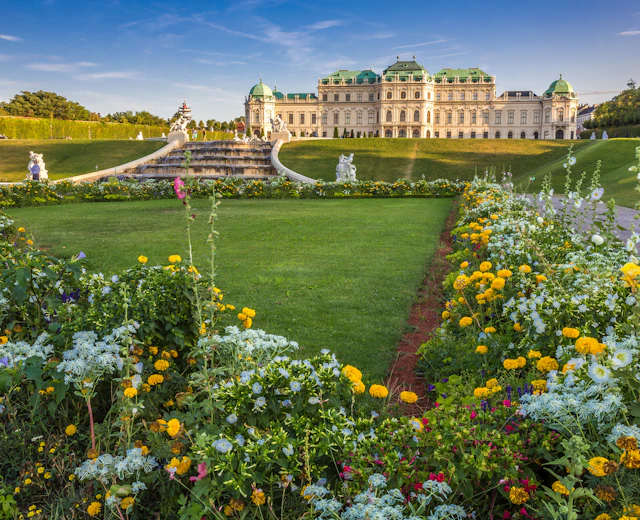 Belvedere Slotspark i Wien med blomstrende sommerblomster i gult og hvidt foran det historiske barokslot
