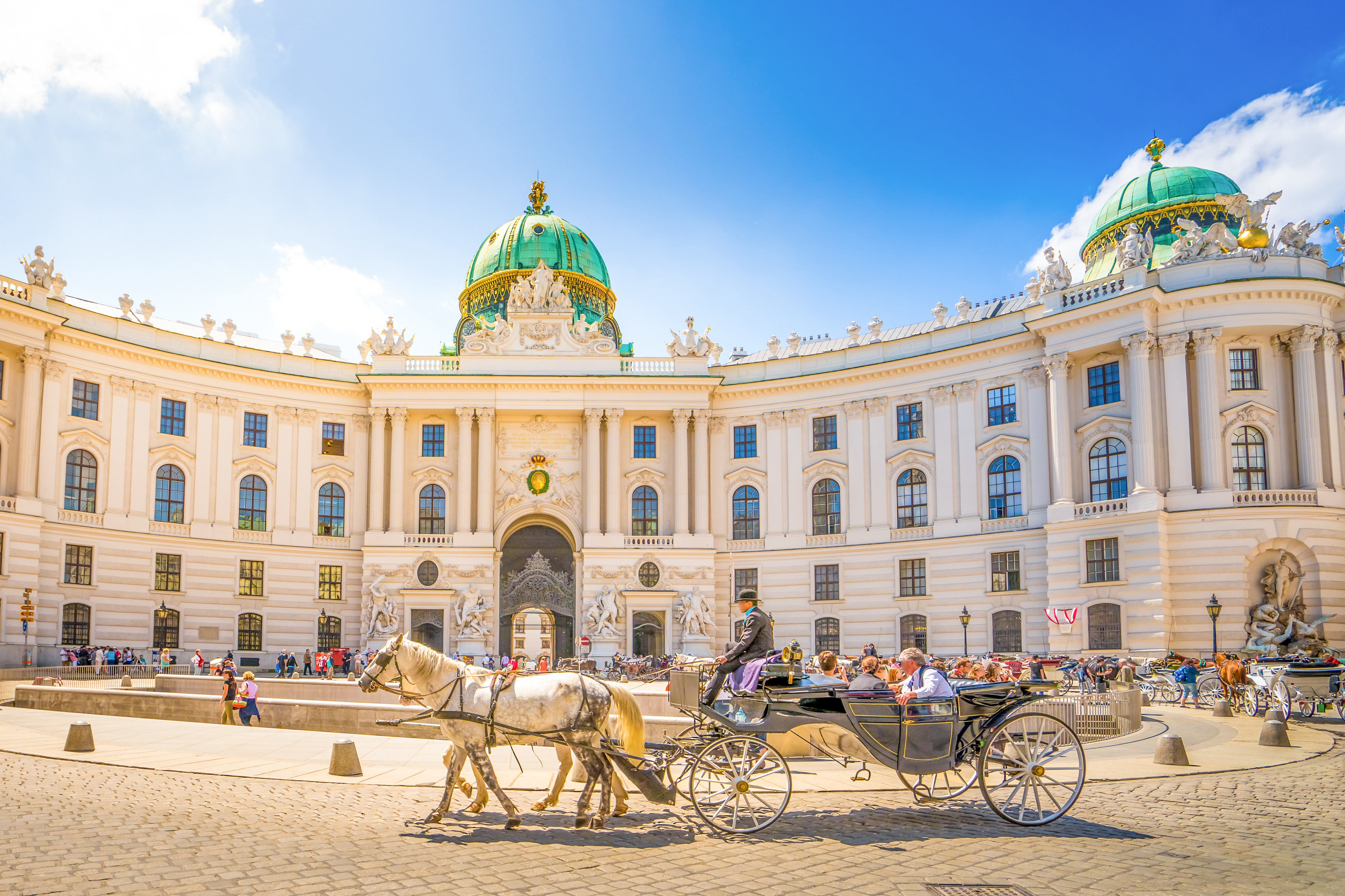 Hestevogn med turister ved det imponerende Hofburg Slot i Wien, Østrigs smukke barokarkitektur