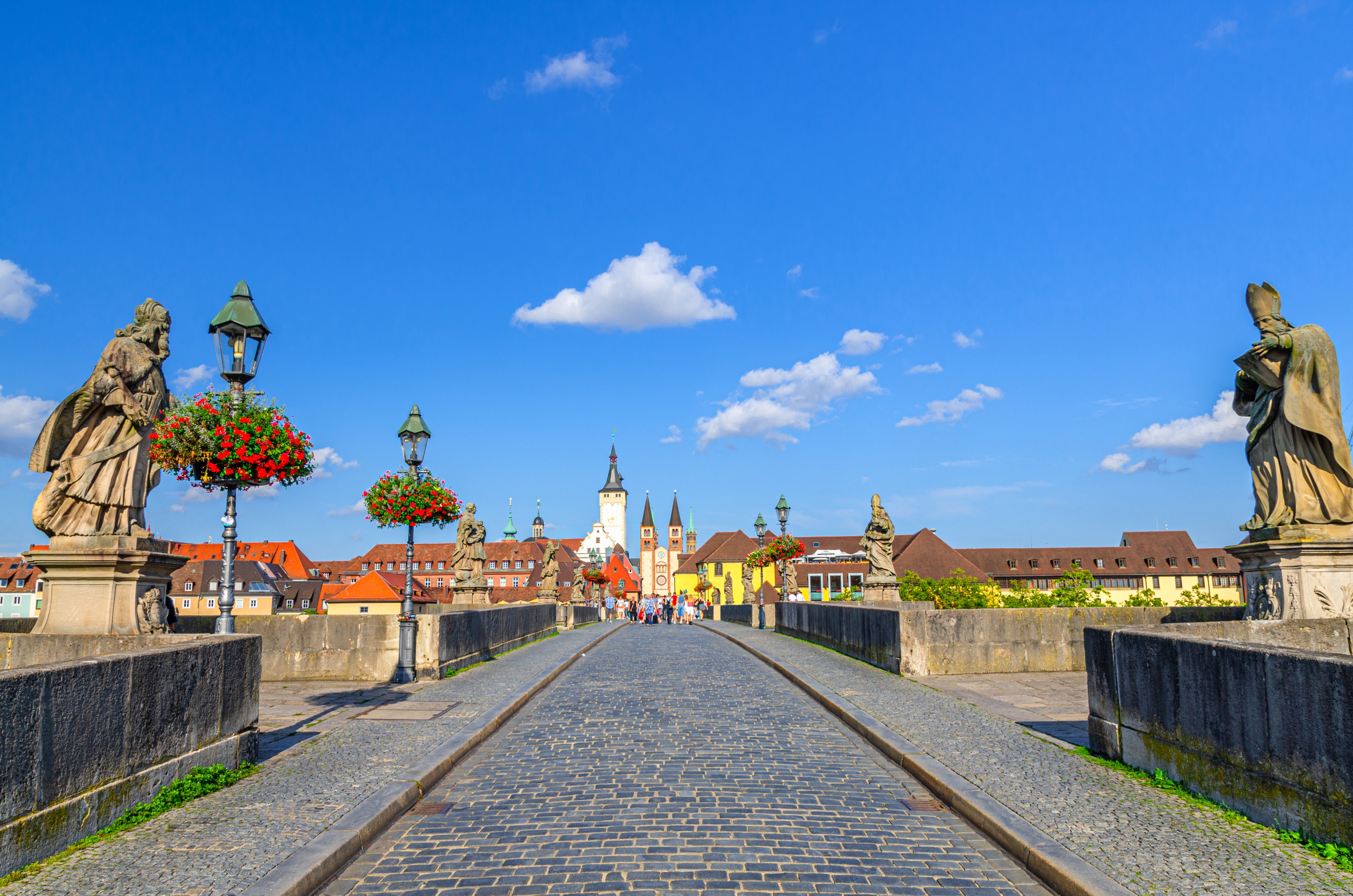 Cobblestone-brosten og barokstatuer på Alte Mainbrücke i Würzburg fører mod den historiske gammelby i Bayern, Tyskland
