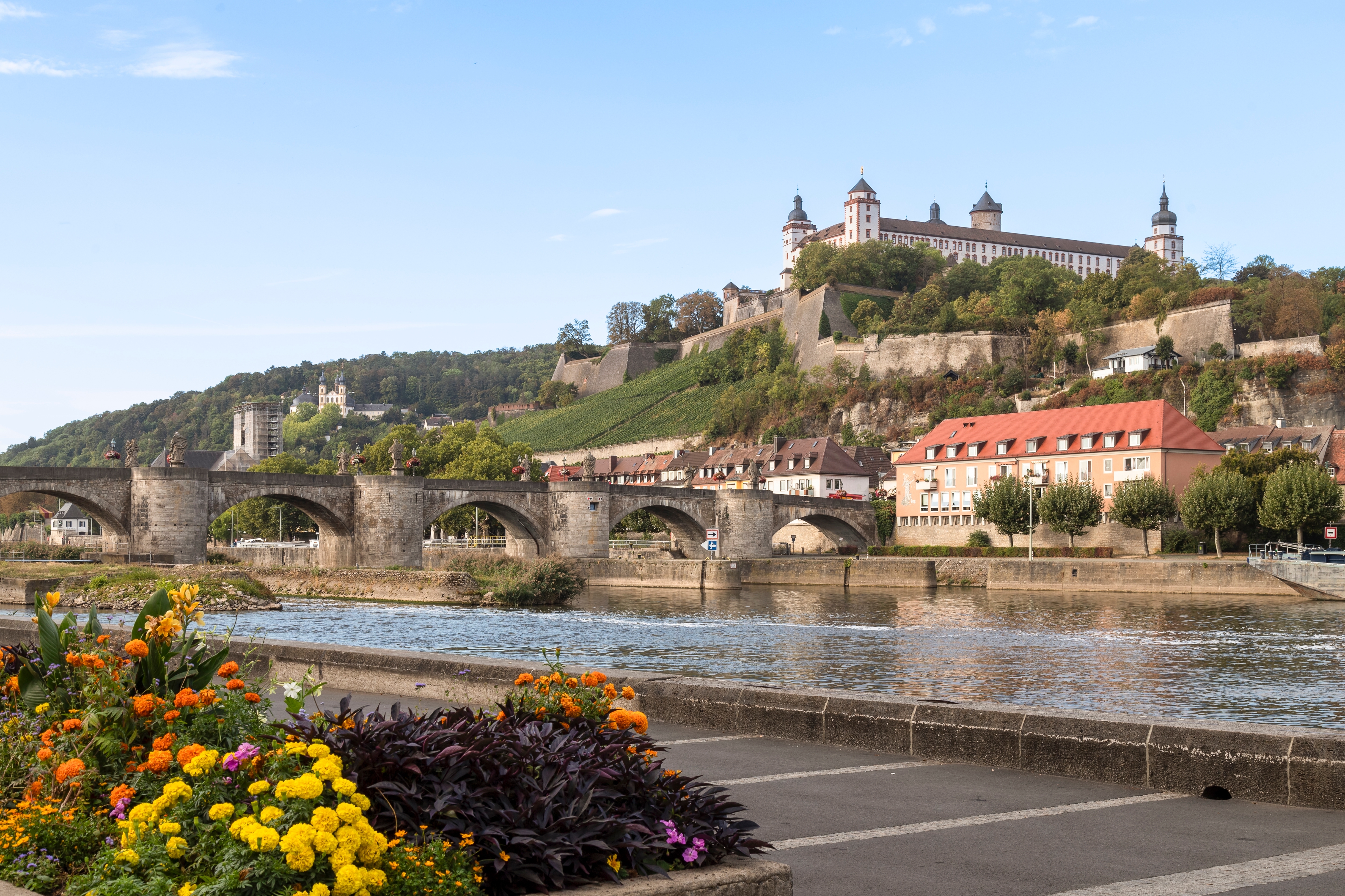 Würzburgs historiske middelalderby med den gamle Mainbro, Marienberg Fæstning og farverige blomster langs flodbredden i Bayern