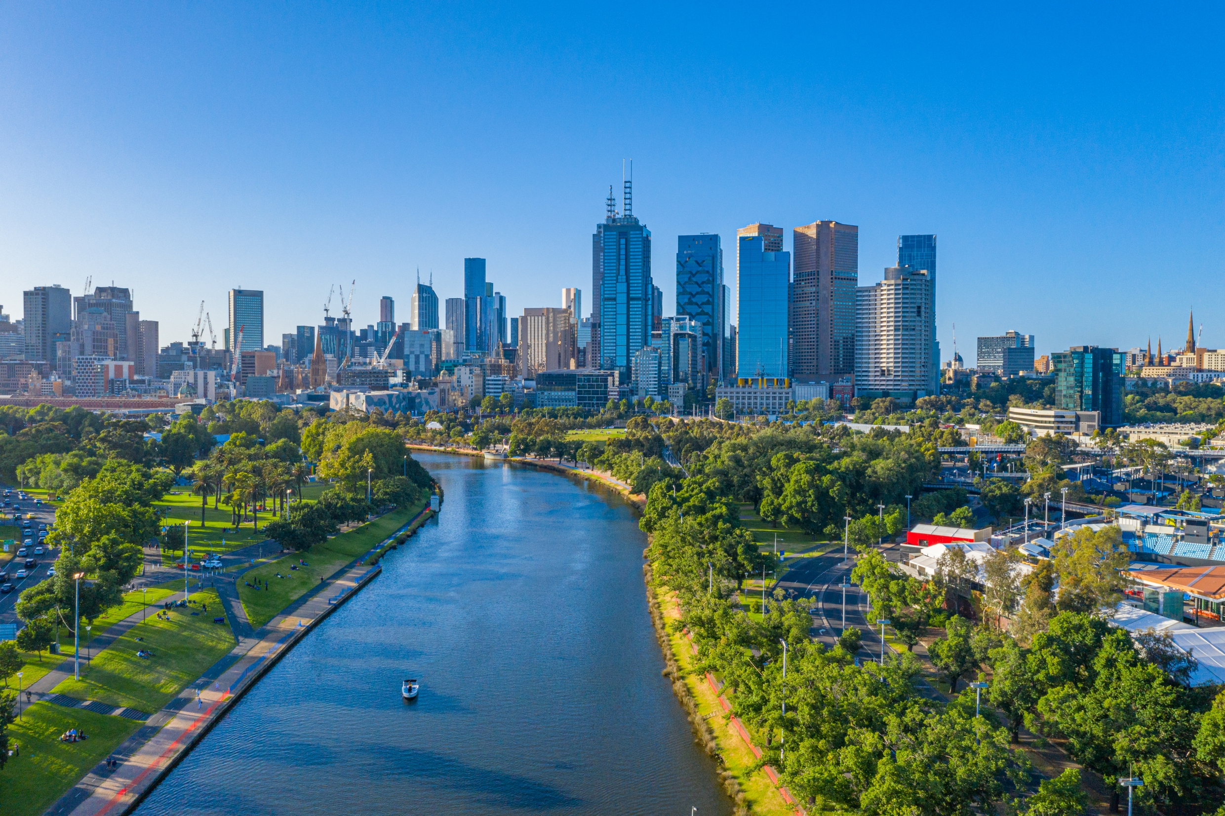 Yarra River med Melbourne skyskrabere i solskin og grønne områder
