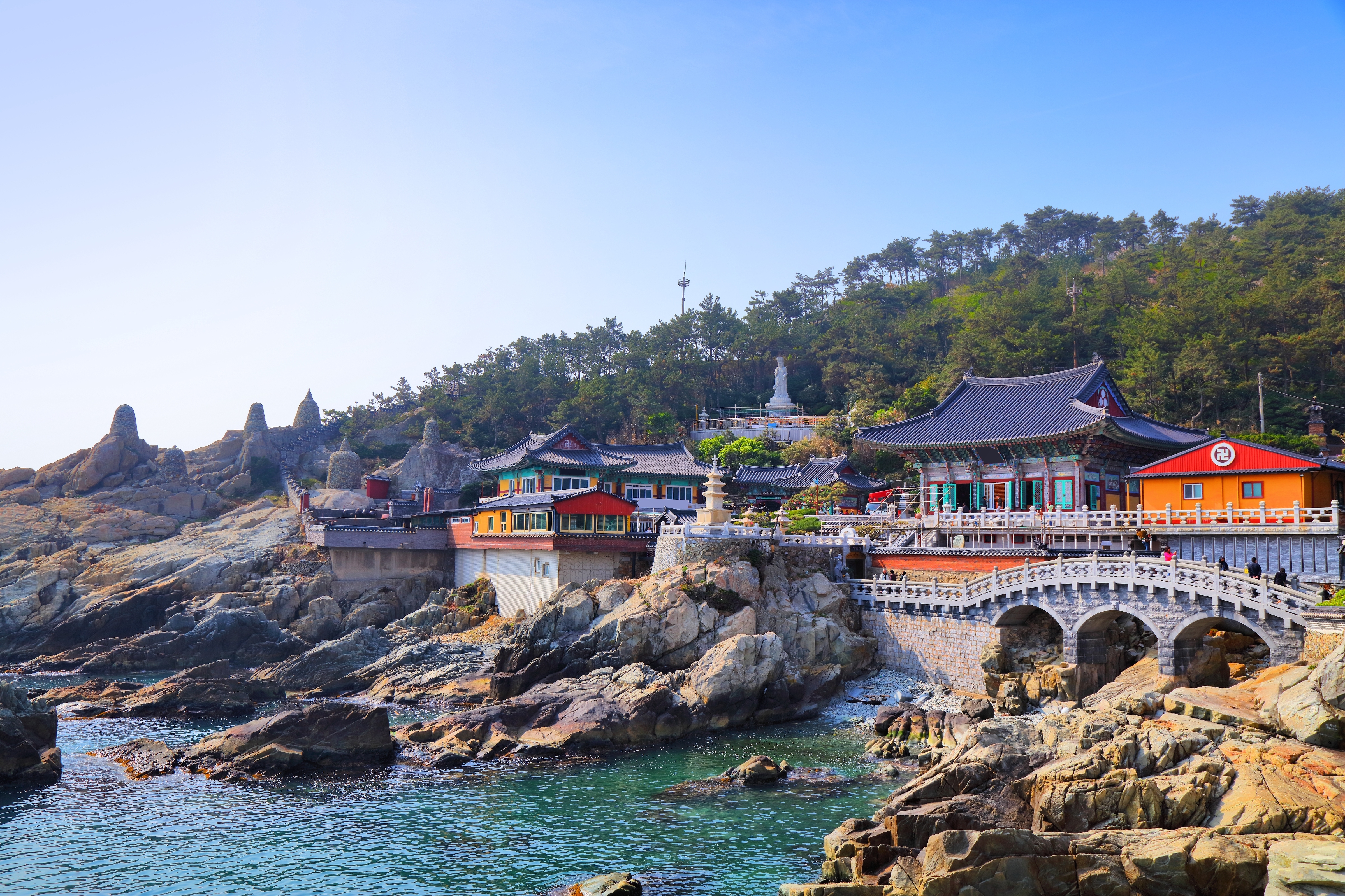 Haedong Yonggungsa tempel i Busan, Sydkorea, med traditionel koreansk arkitektur placeret direkte ved den rocky kystlinje