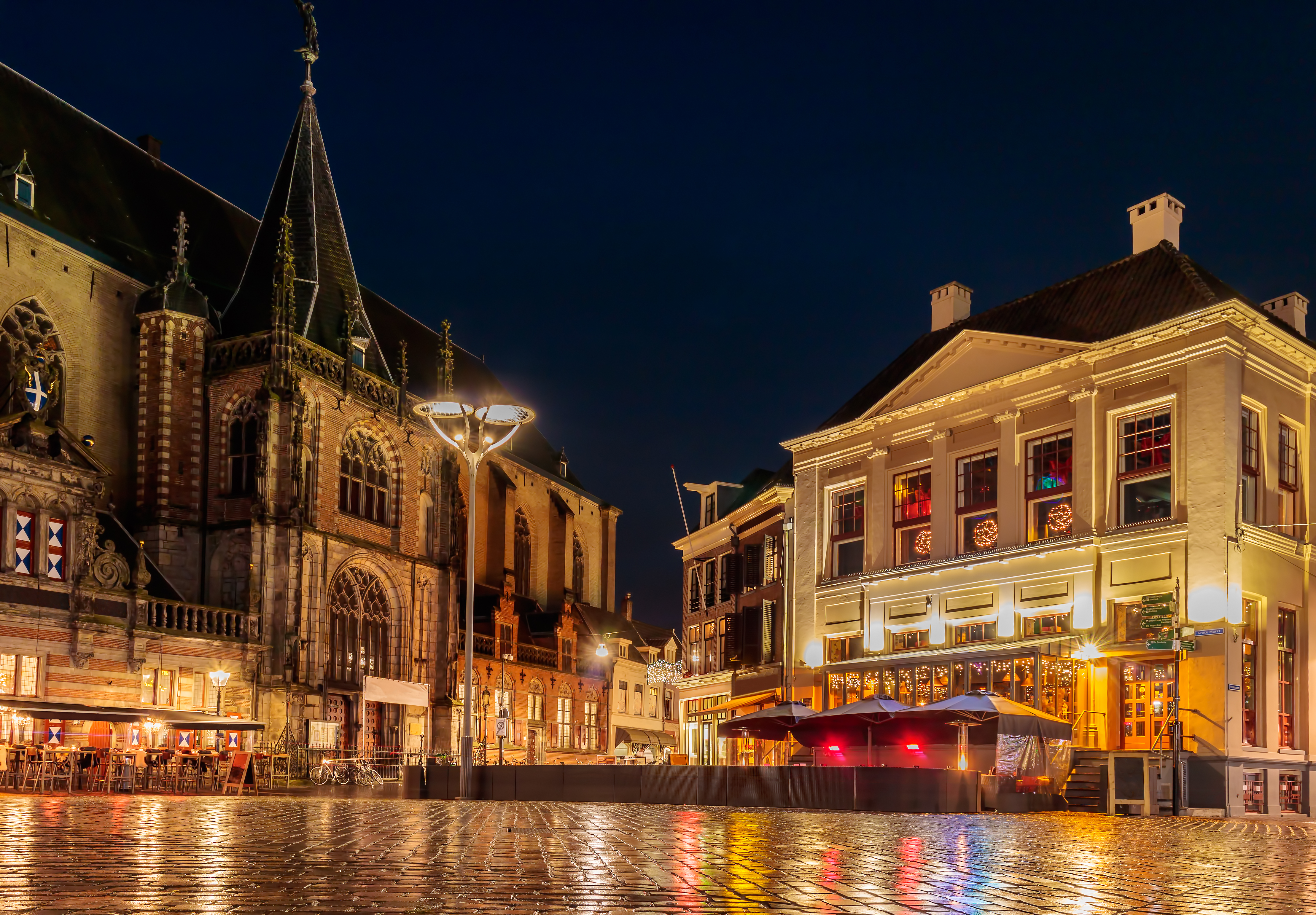 Zwolle centrum i Holland med oplyst gotisk kirke og hyggelige restauranter om natten
